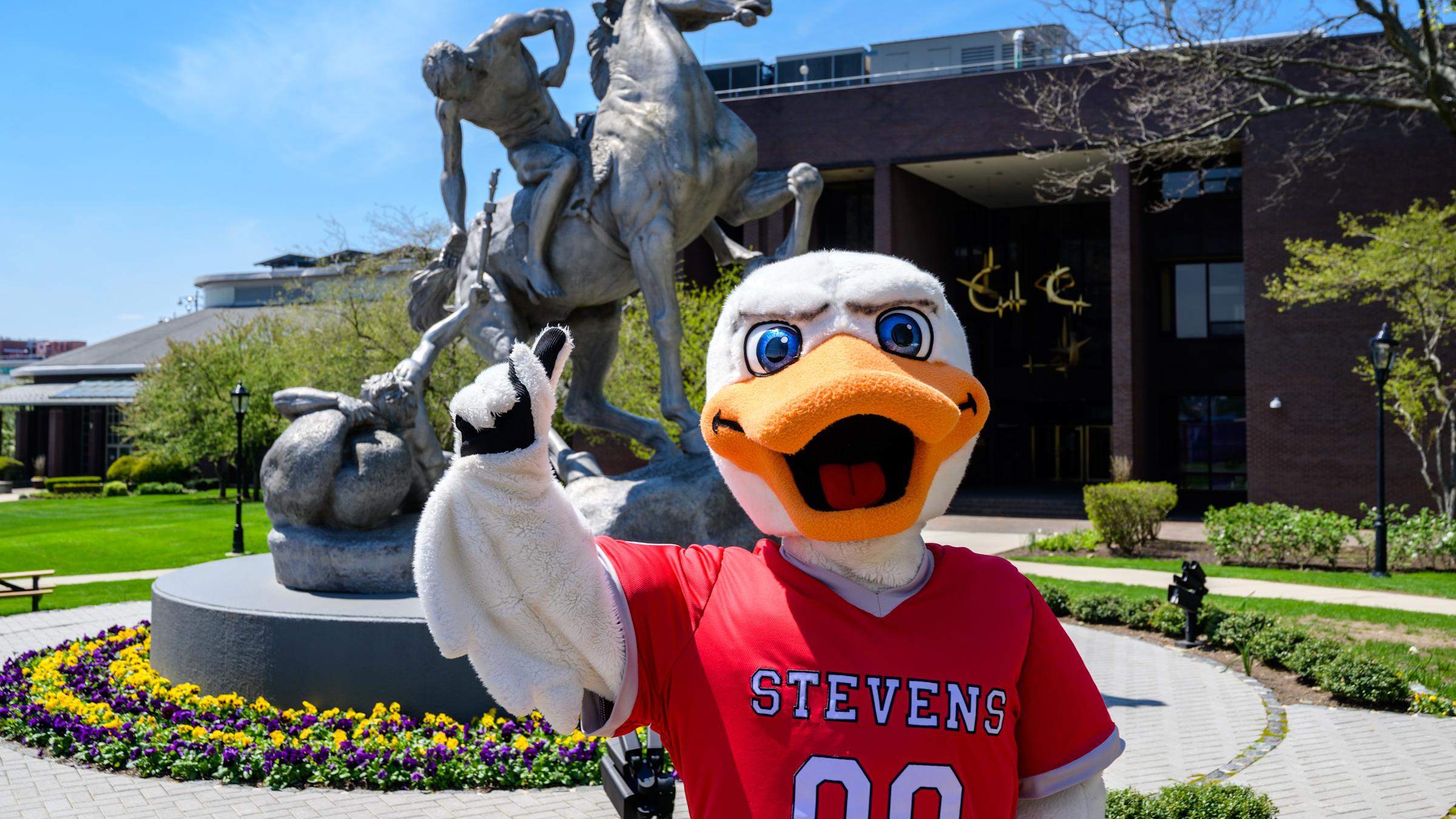 Attila mascot in front of Torch Bearers sculpture on campus