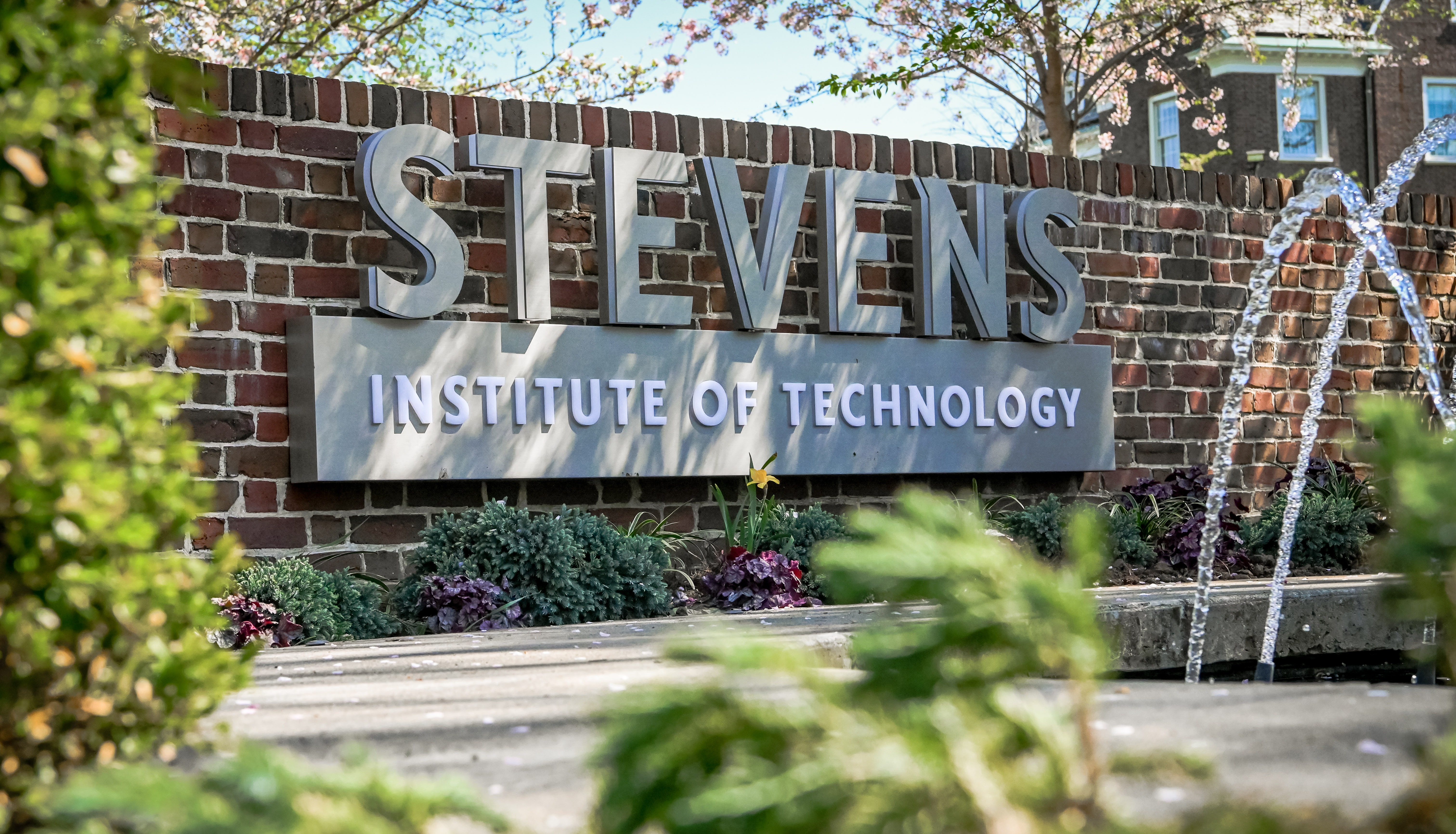 Stevens wordmark on brick wall behind Hoxie House fountain
