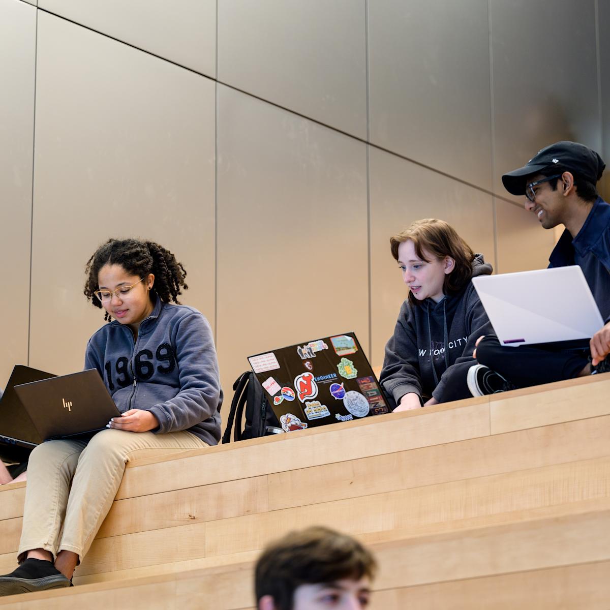 Students sit on the steps in Gateway, working and studying together, at Stevens Institute of Technology