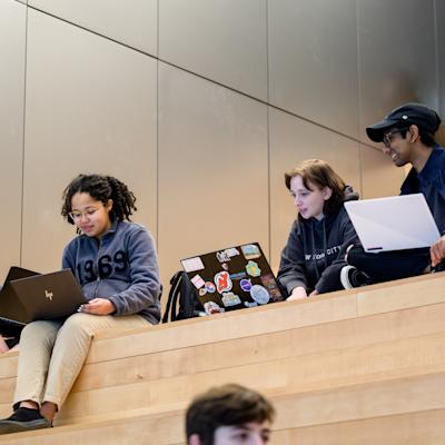 Students sit on the steps in Gateway, working and studying together, at Stevens Institute of Technology