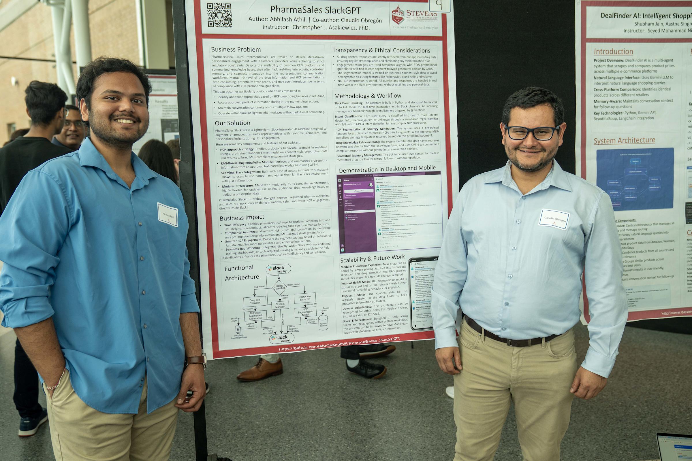 Two students smile standing in front of their research