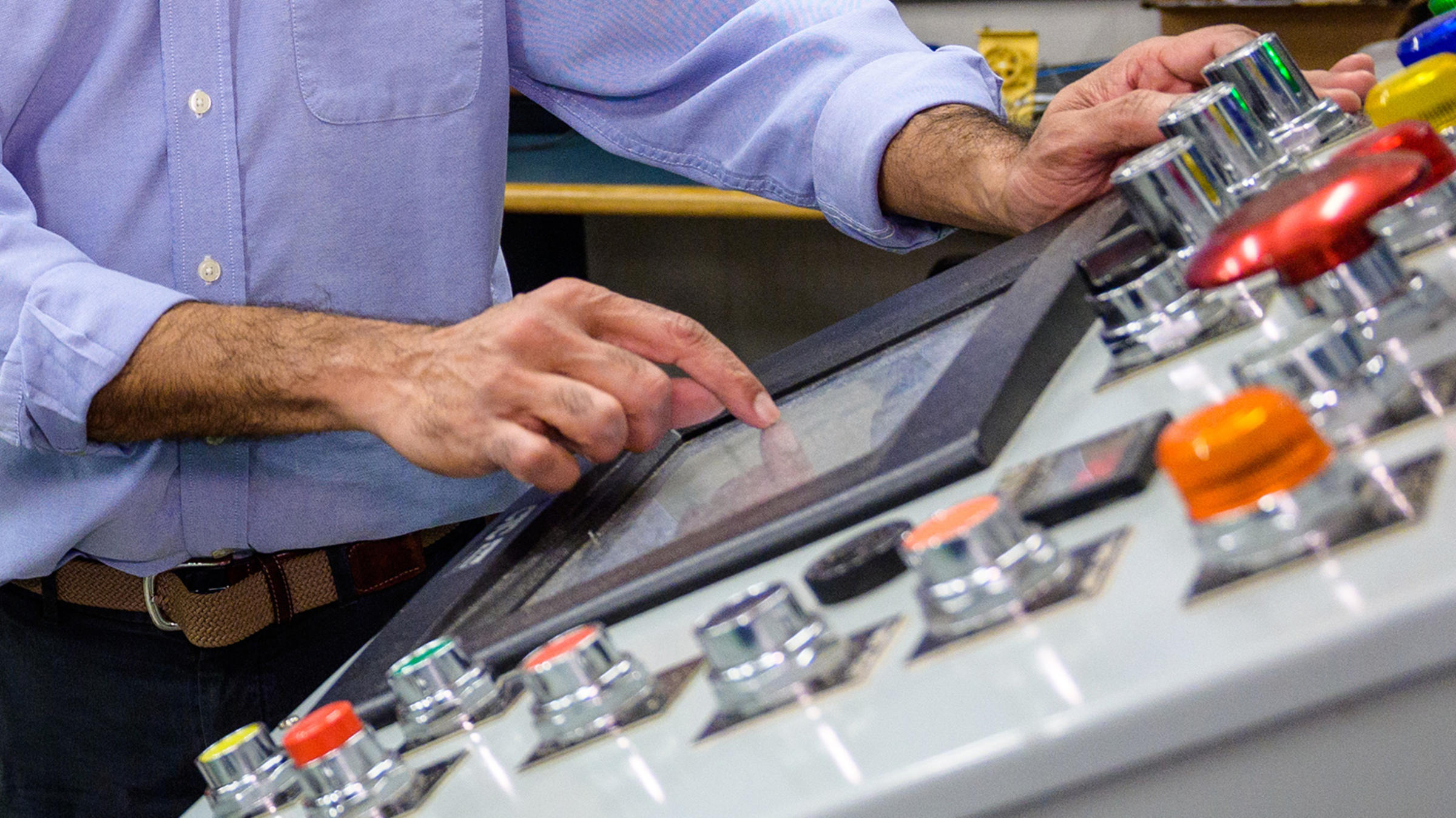A pair of hands working a control panel in the Davidson Lab at Stevens.