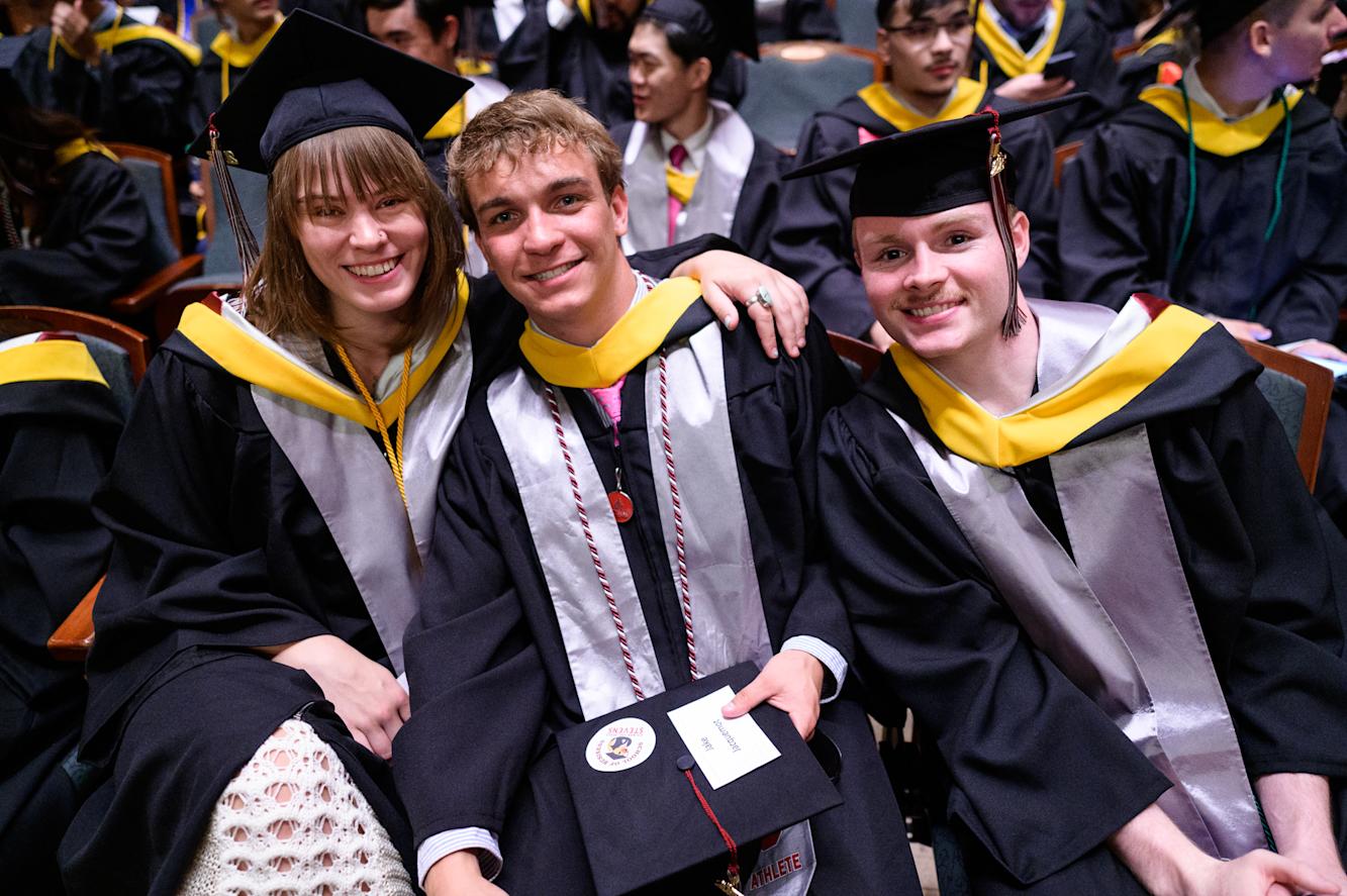 Group of graduates pose for pictures before the ceremony