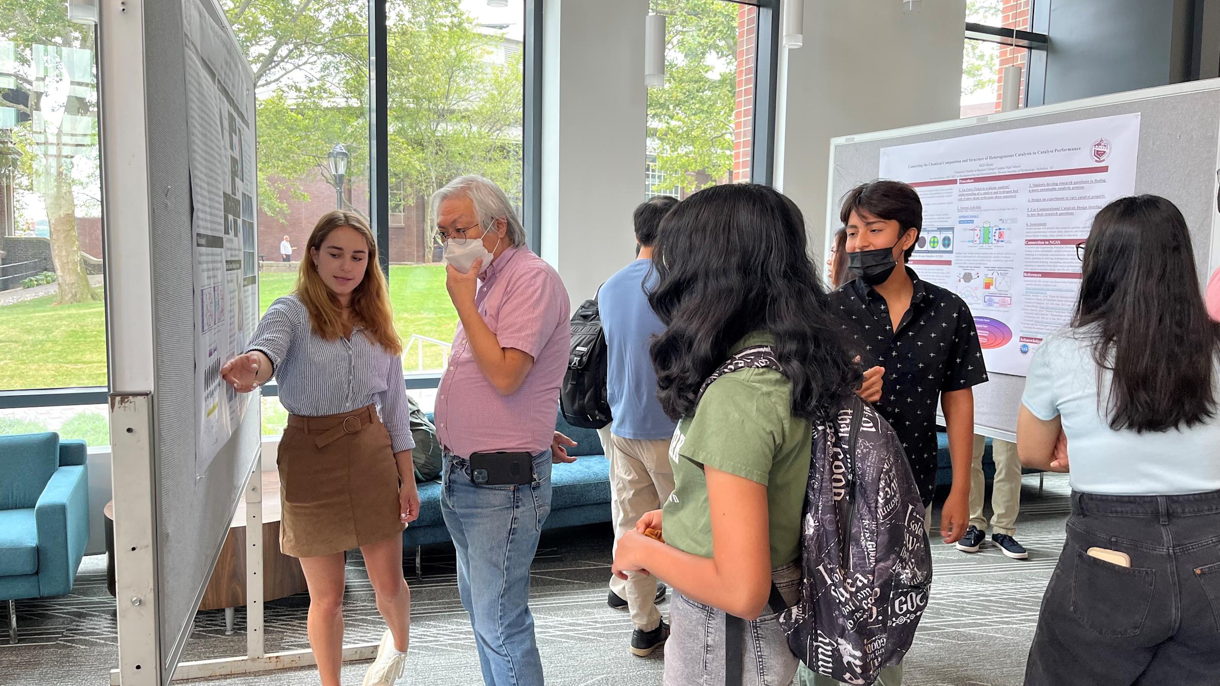 2022 REU student Grace McGraw gives a poster presentation to Kenny Wong