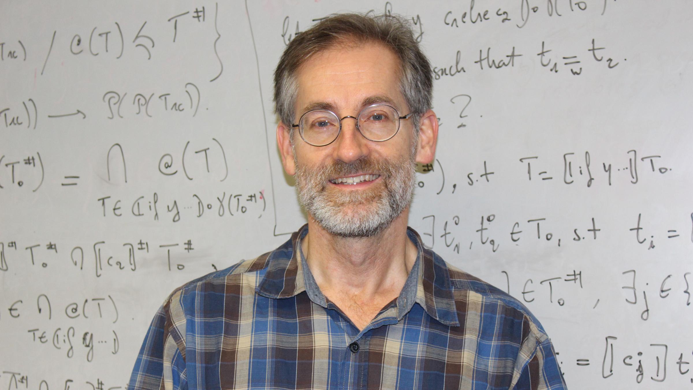 Computer Science Department Chair Dave Naumann in front of whiteboard
