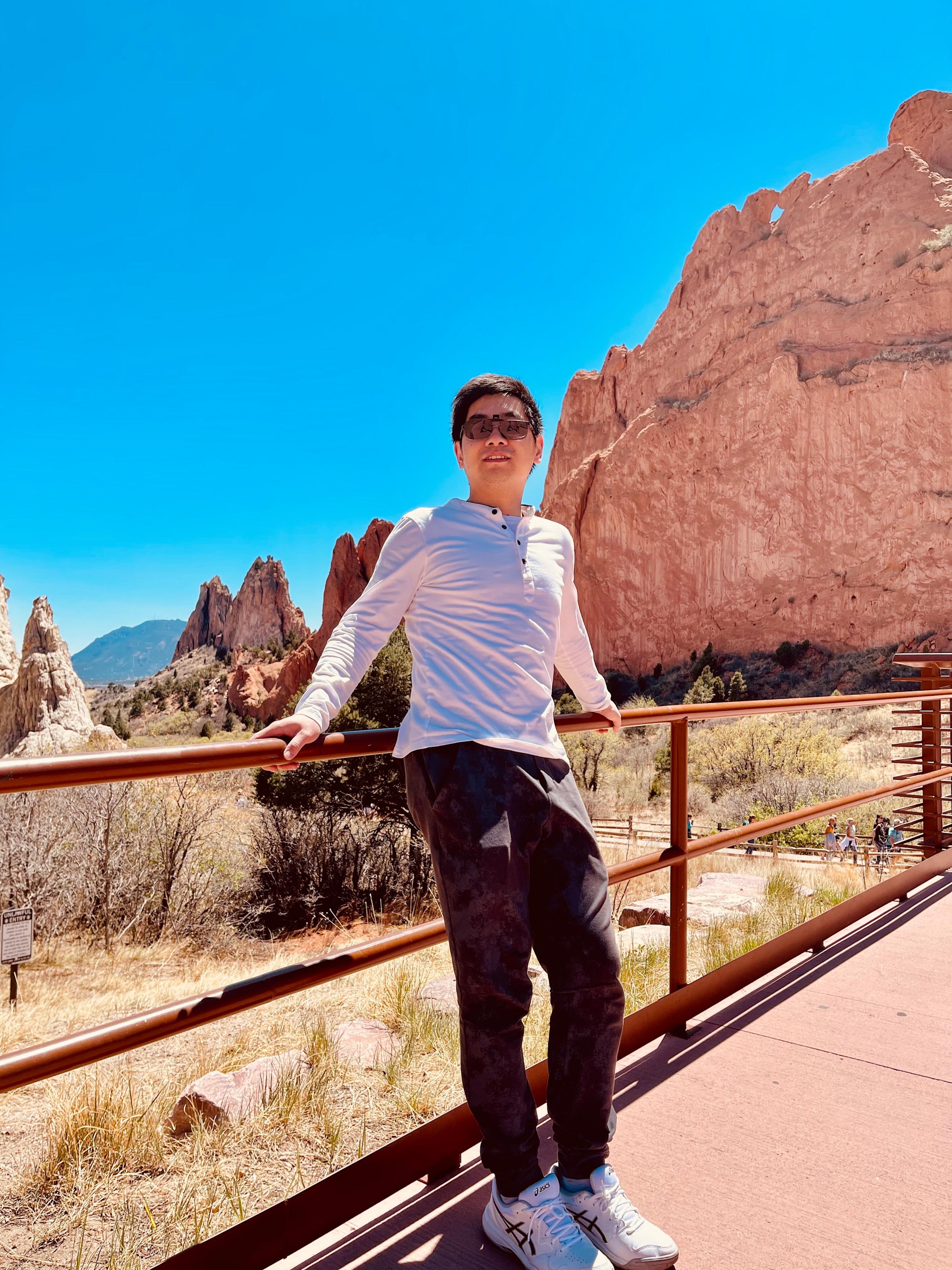 Shucheng standing before majestic desert mountains.