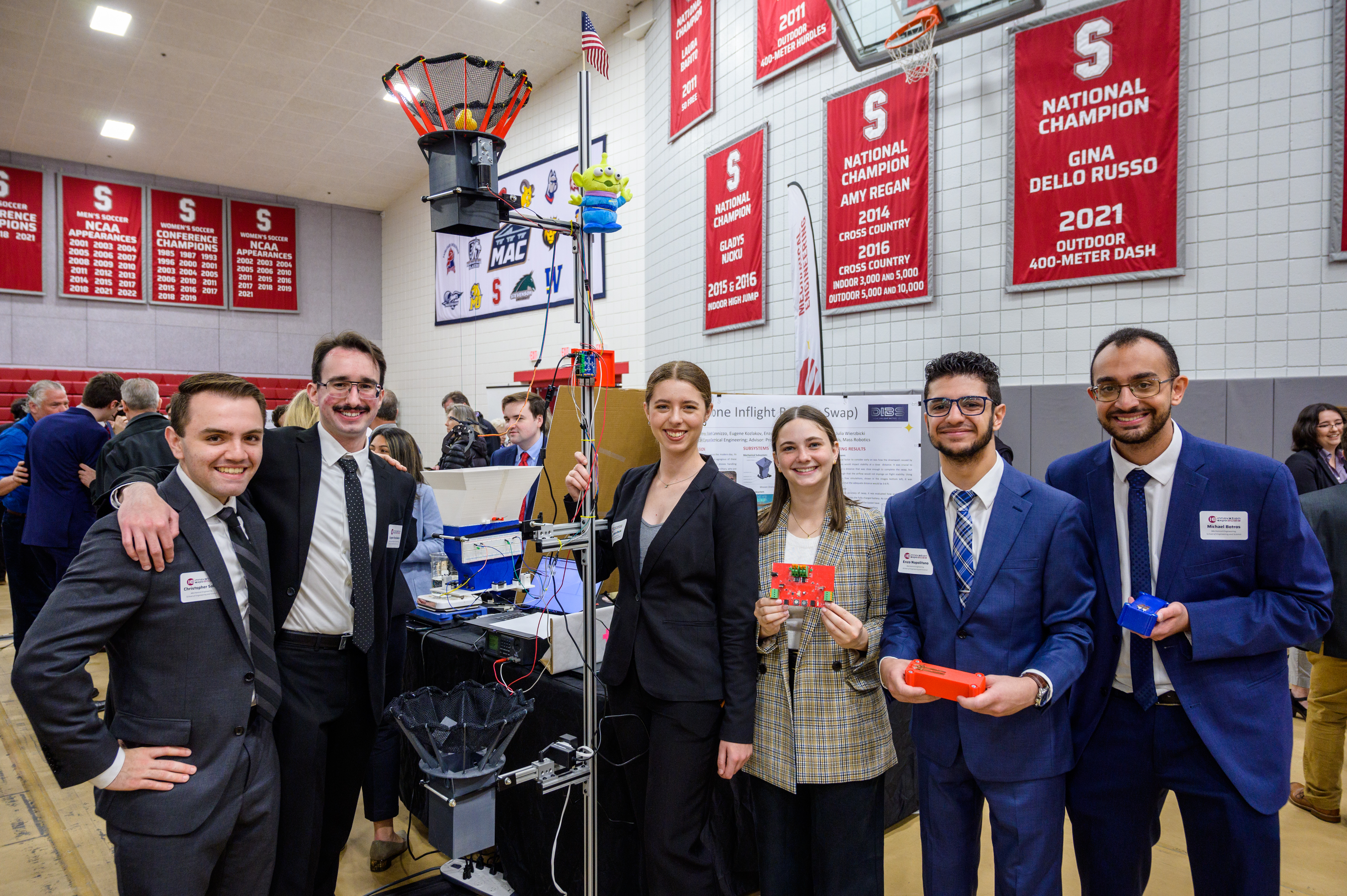 Students pose alongside their senior capstone project during Innovation Expo 2023 at Stevens.