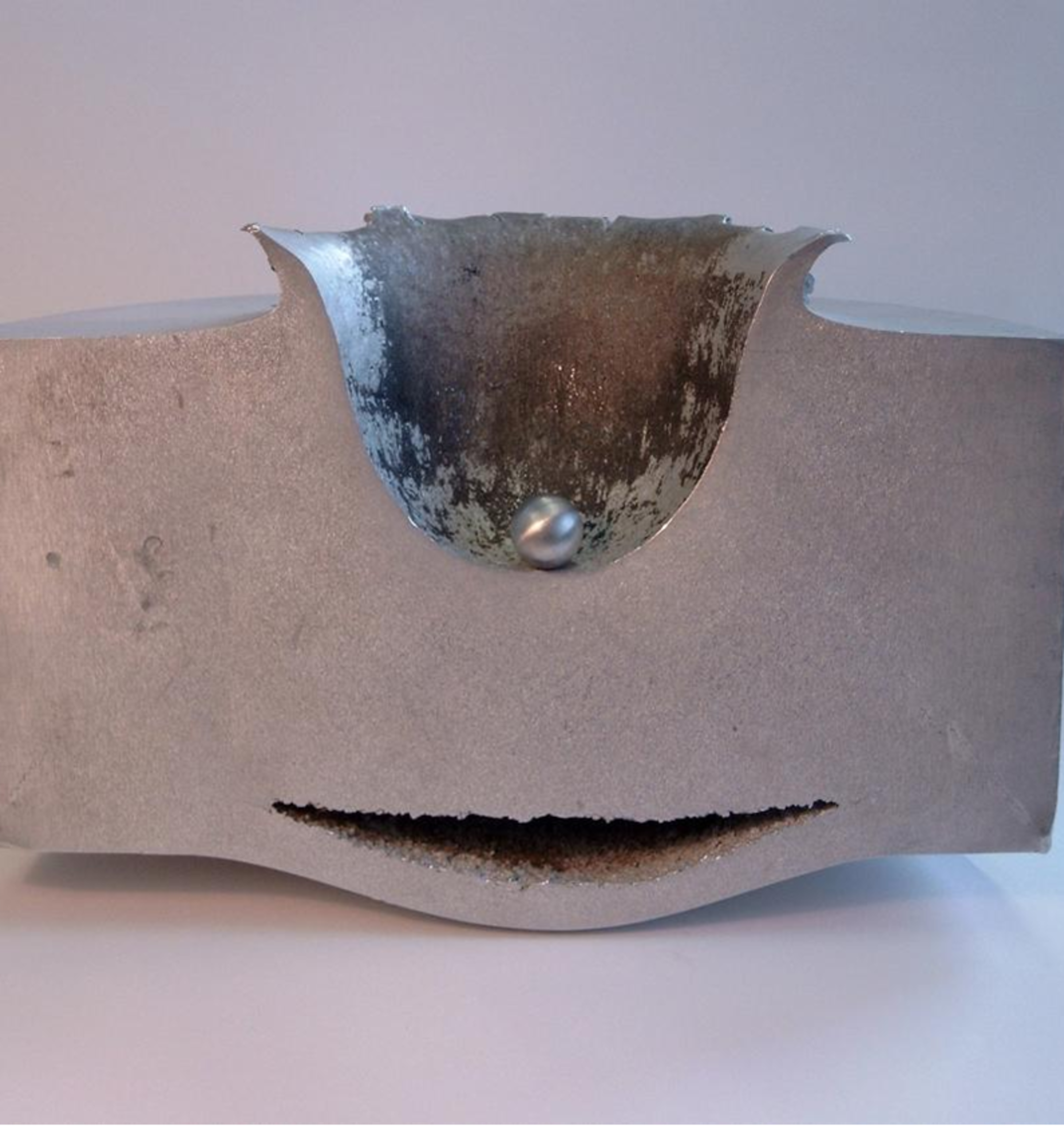This image shows the results of a lab test impact between a small sphere of aluminum travelling at approximately 6.8 km/second and a block of aluminum 18 cm thick.