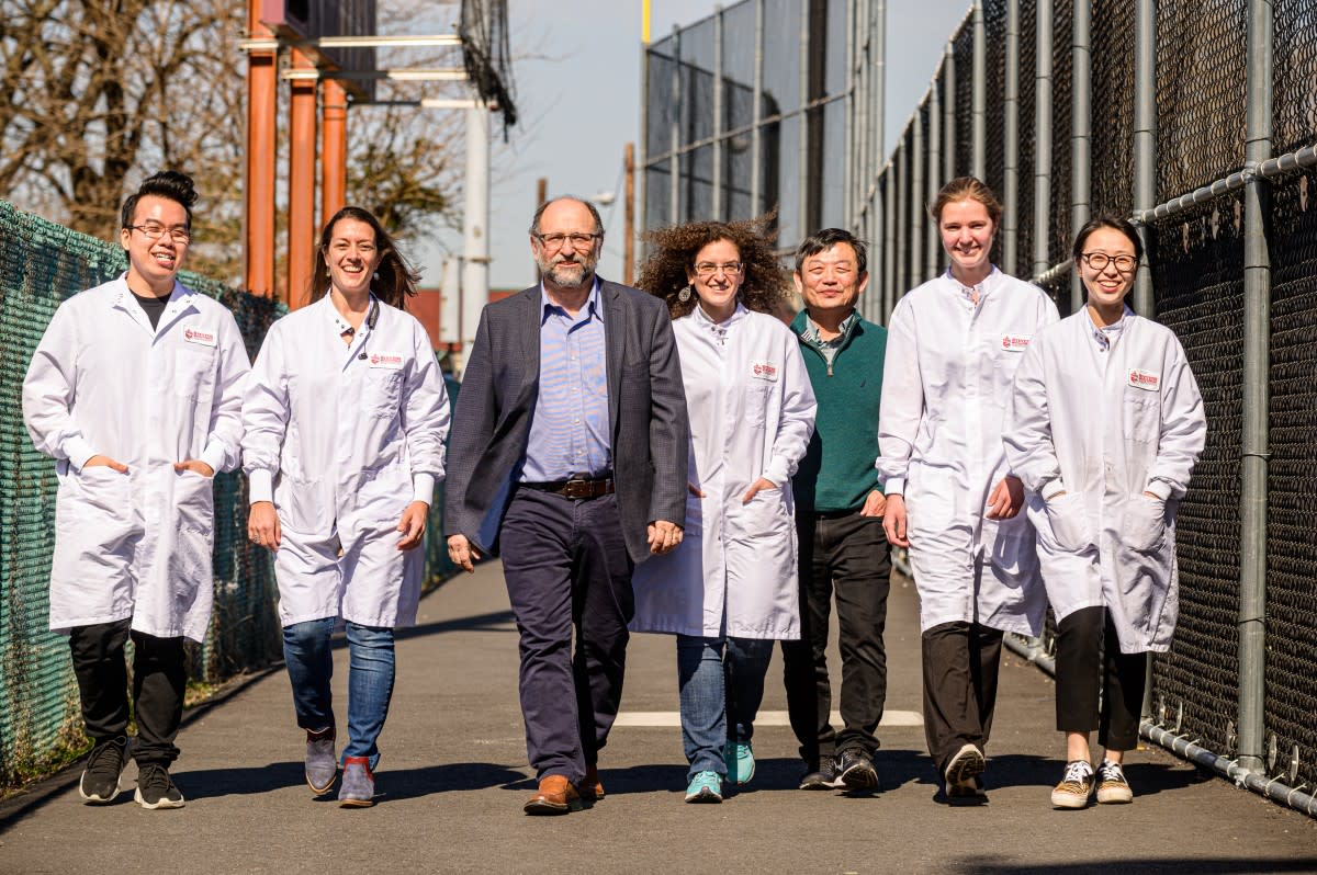 Professor and students in lab coats