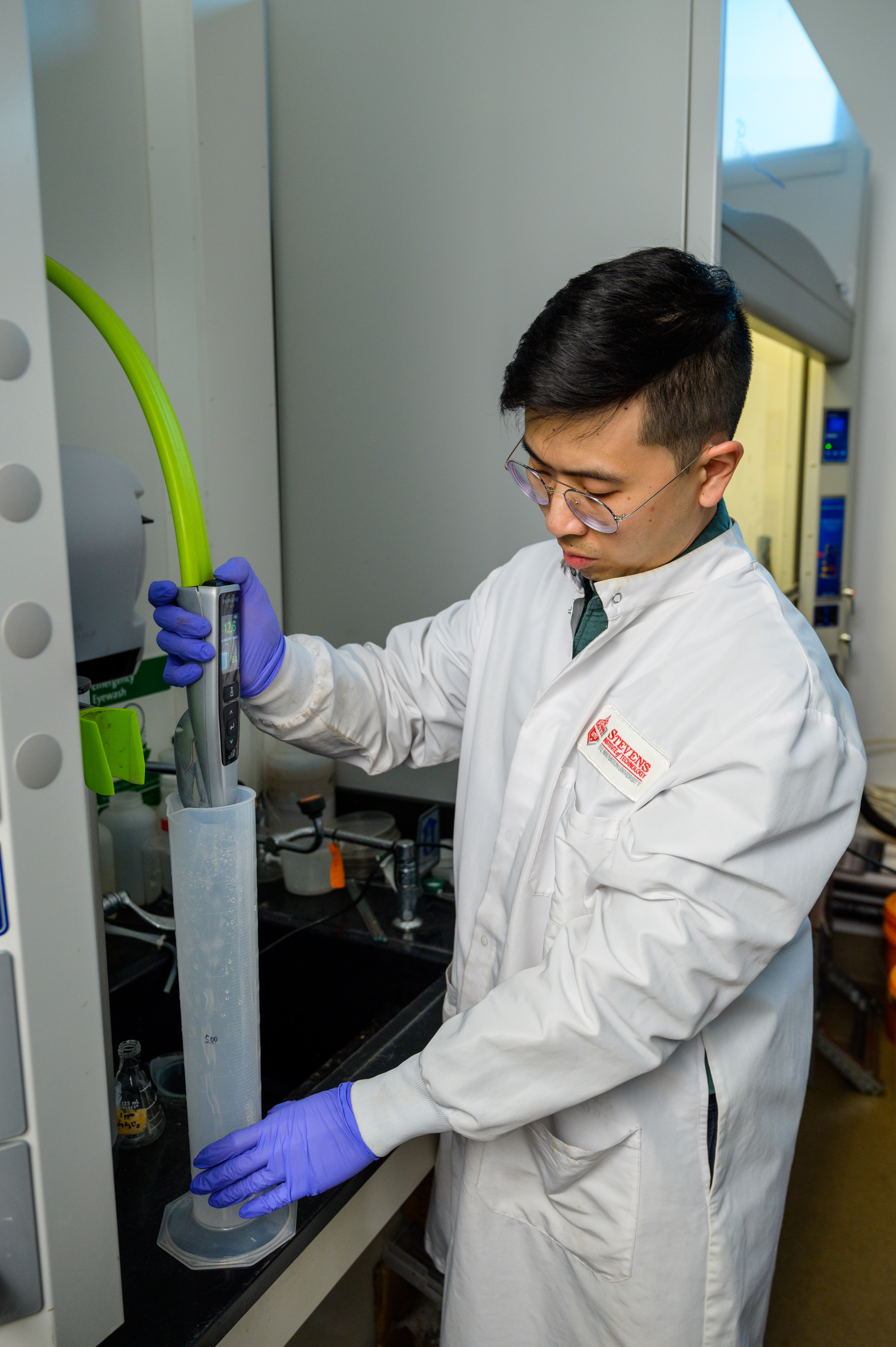 Viravid Na Nagara transferring liquid to a large tube in lab