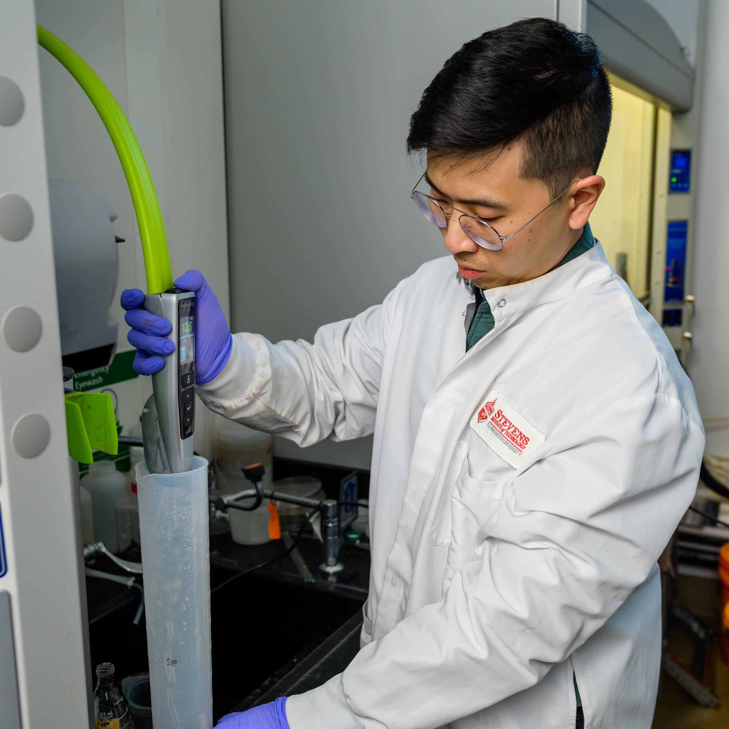 Viravid Na Nagara transferring liquid to a large tube in lab