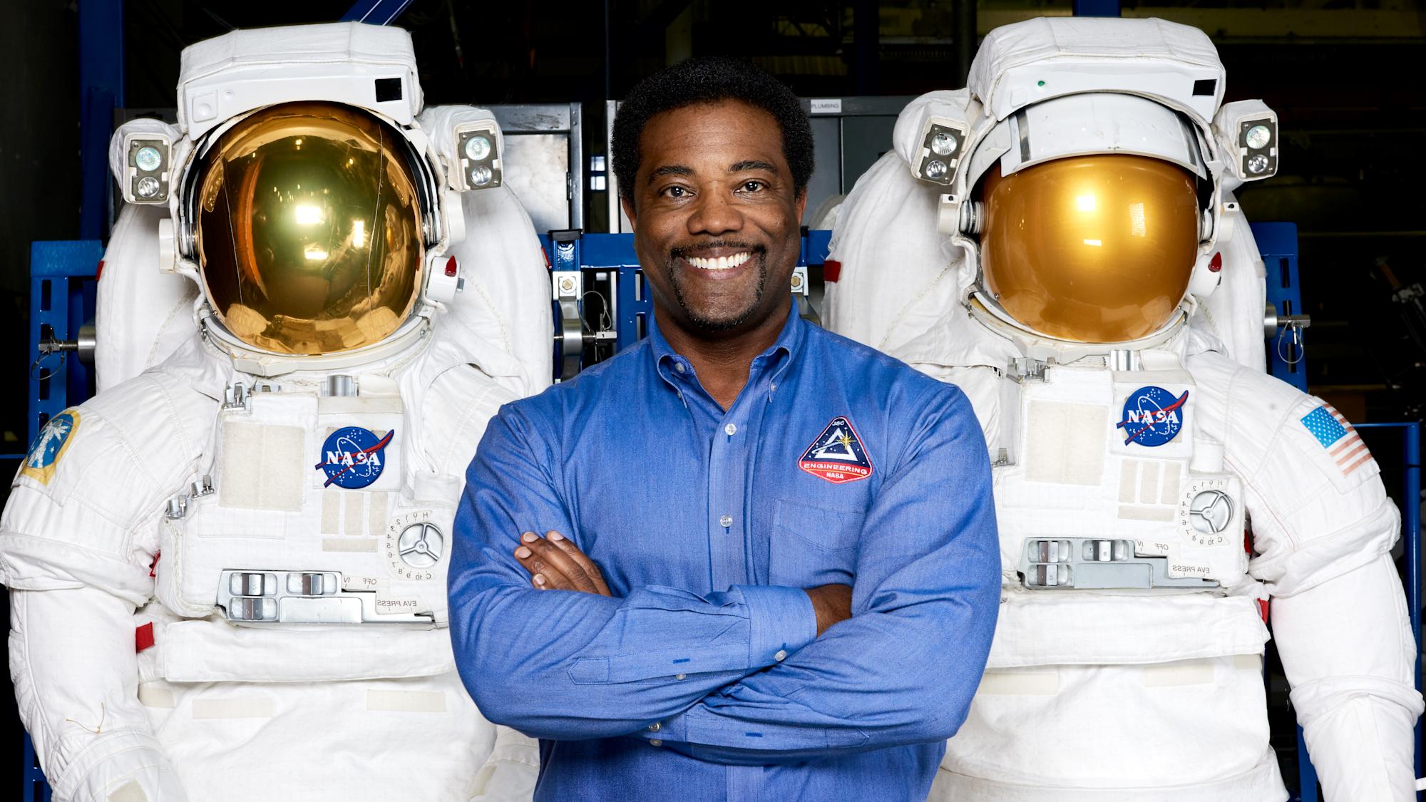 Ron Cobbs smile for the camera between two space suits.