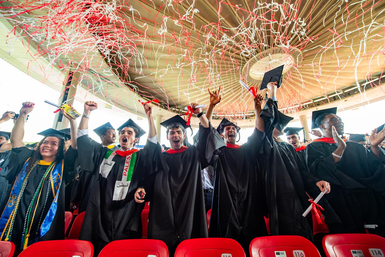 Graduates celebrate under confetti