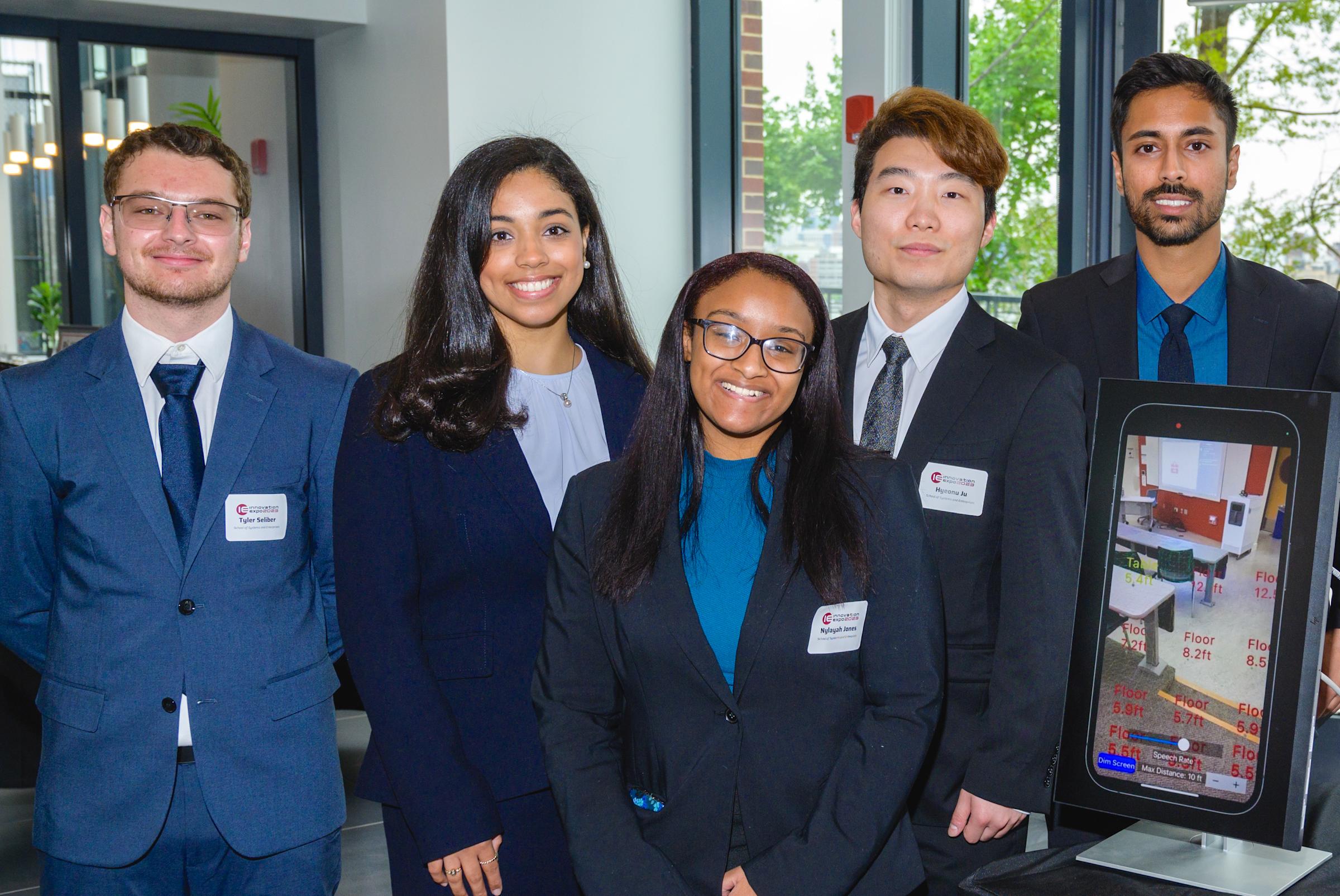 Team of student in front of presentation for iPhone app in Stevens' University Center Complex