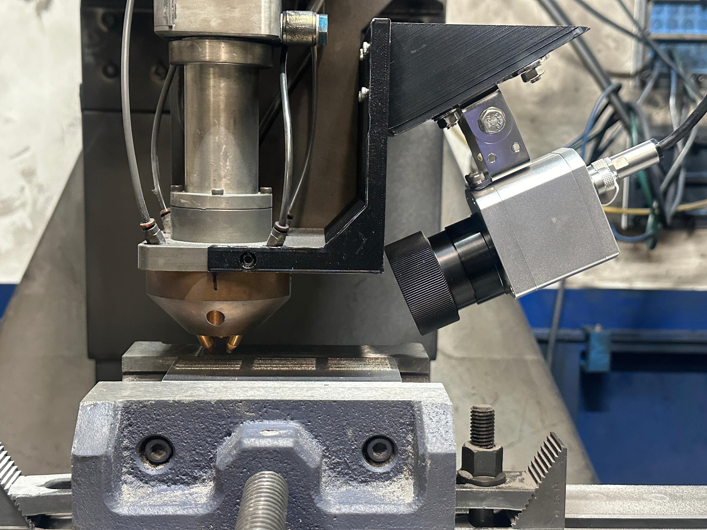 Infrared camera mounted on the deposition head inside a Directed Energy Deposition machine for real-time process monitoring.
