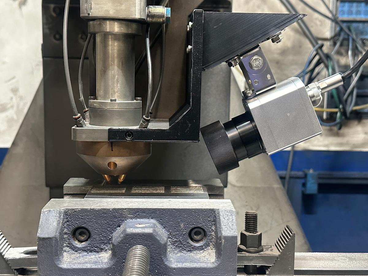 Infrared camera mounted on the deposition head inside a Directed Energy Deposition machine for real-time process monitoring.
