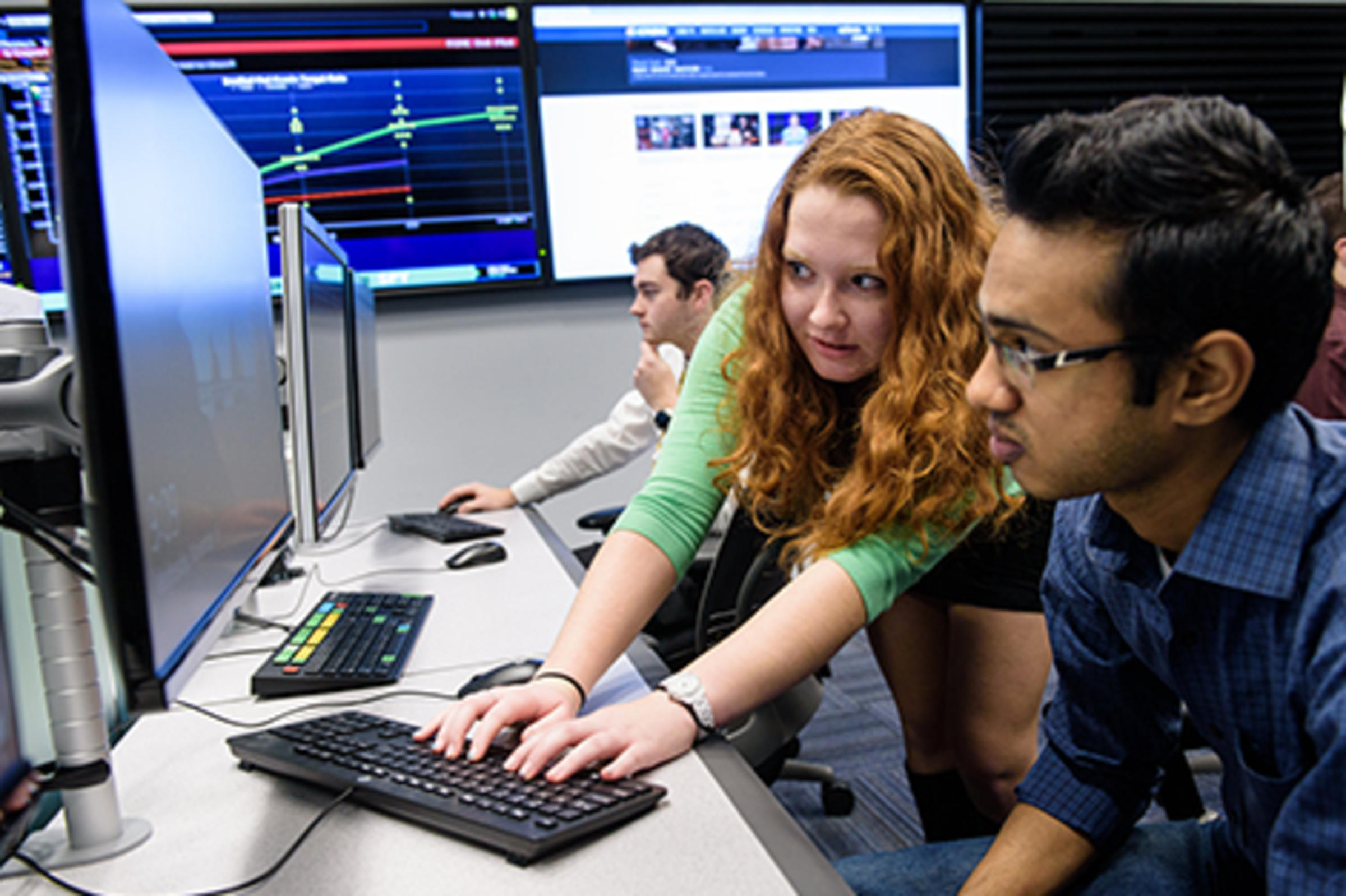 Two students working on a computer in a lab.