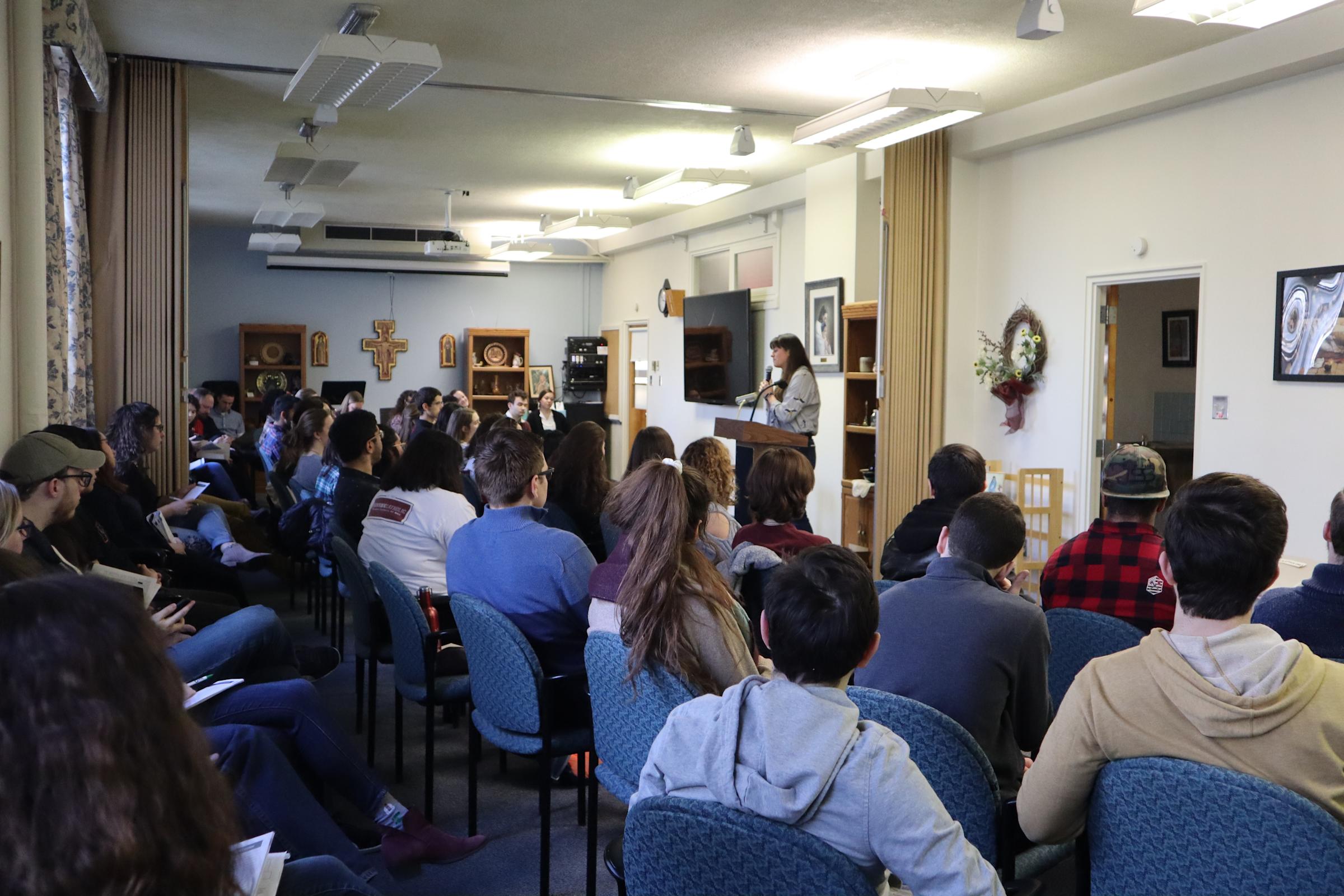 Group of students listening to a speaker at a podium