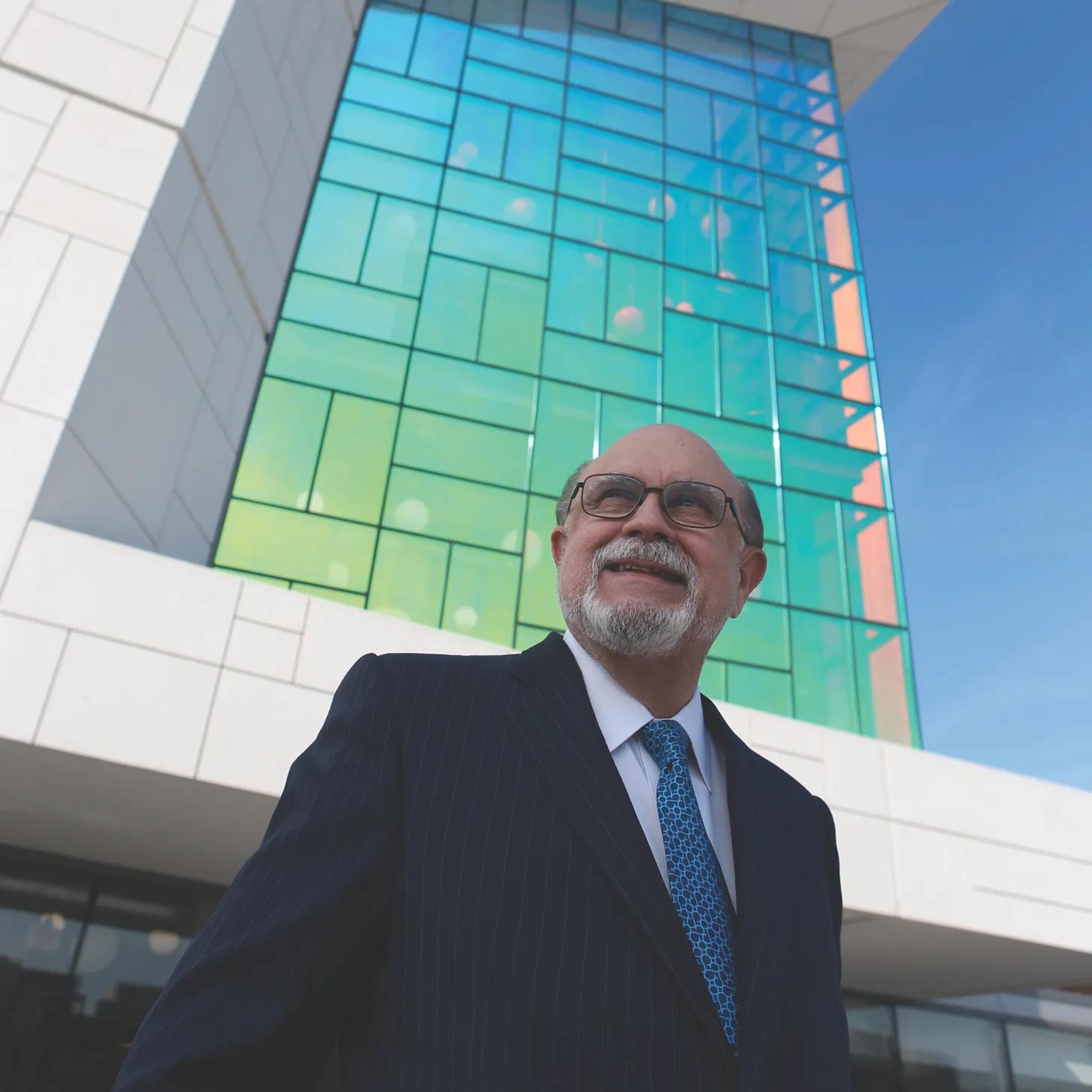 Emilio Fernandez stands in front of a glass building.