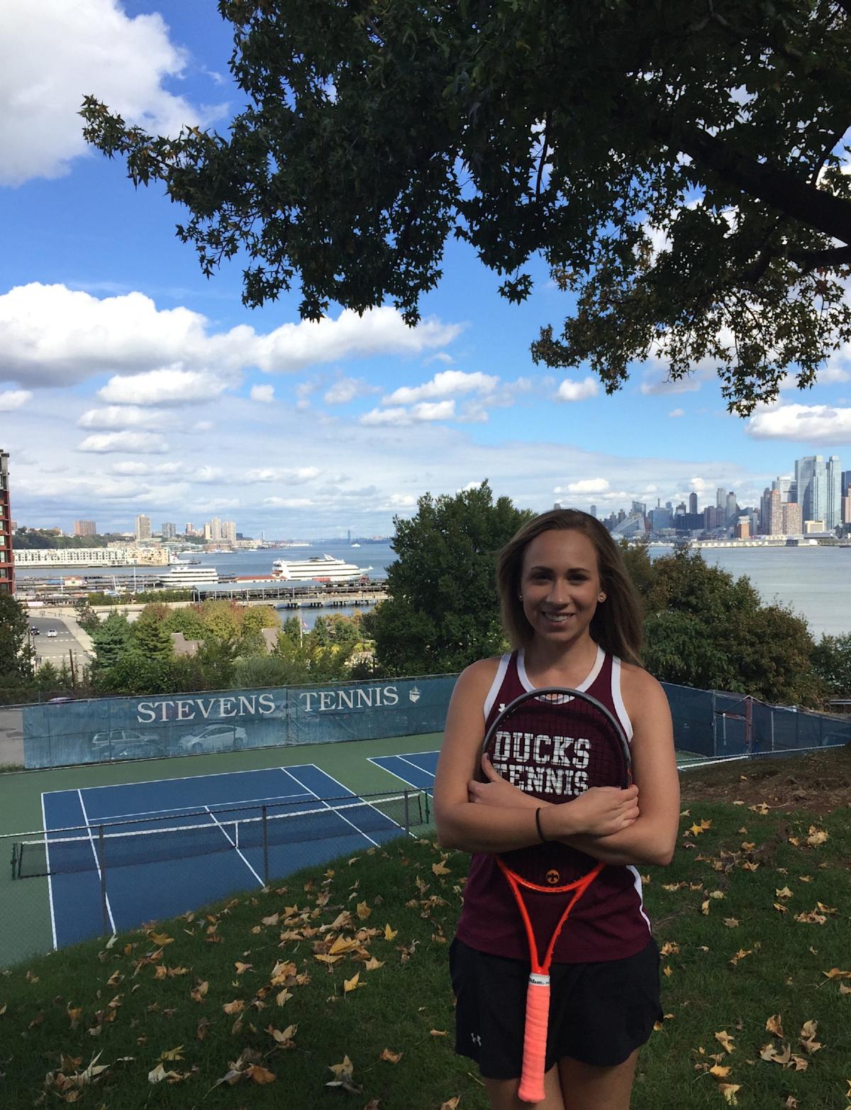 Arden Servidio ’17 M.Eng. ’17 as a student in tennis uniform in front of the tennis courts on campus