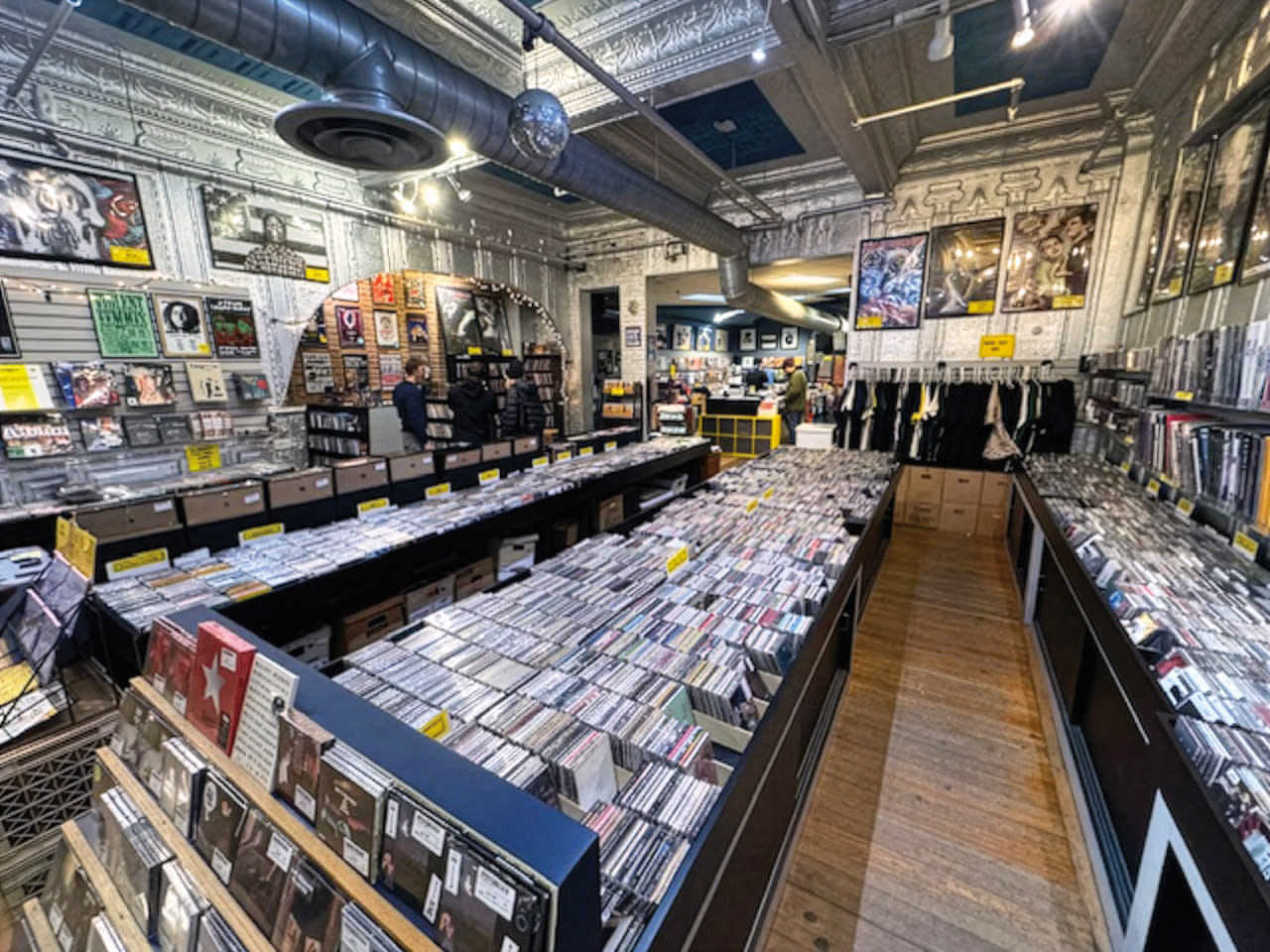Photo of a record store with bins of vinyl albums, with an illustration of a record player attached.