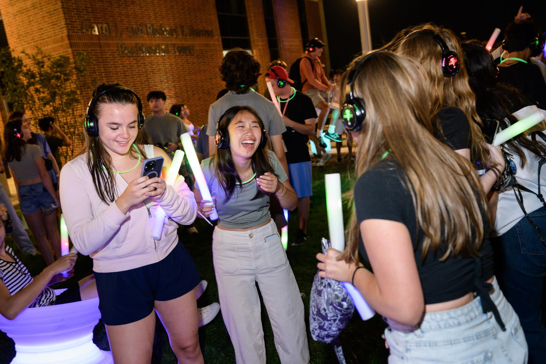 Students wear headphones and laugh during the silent disco near the UCC.