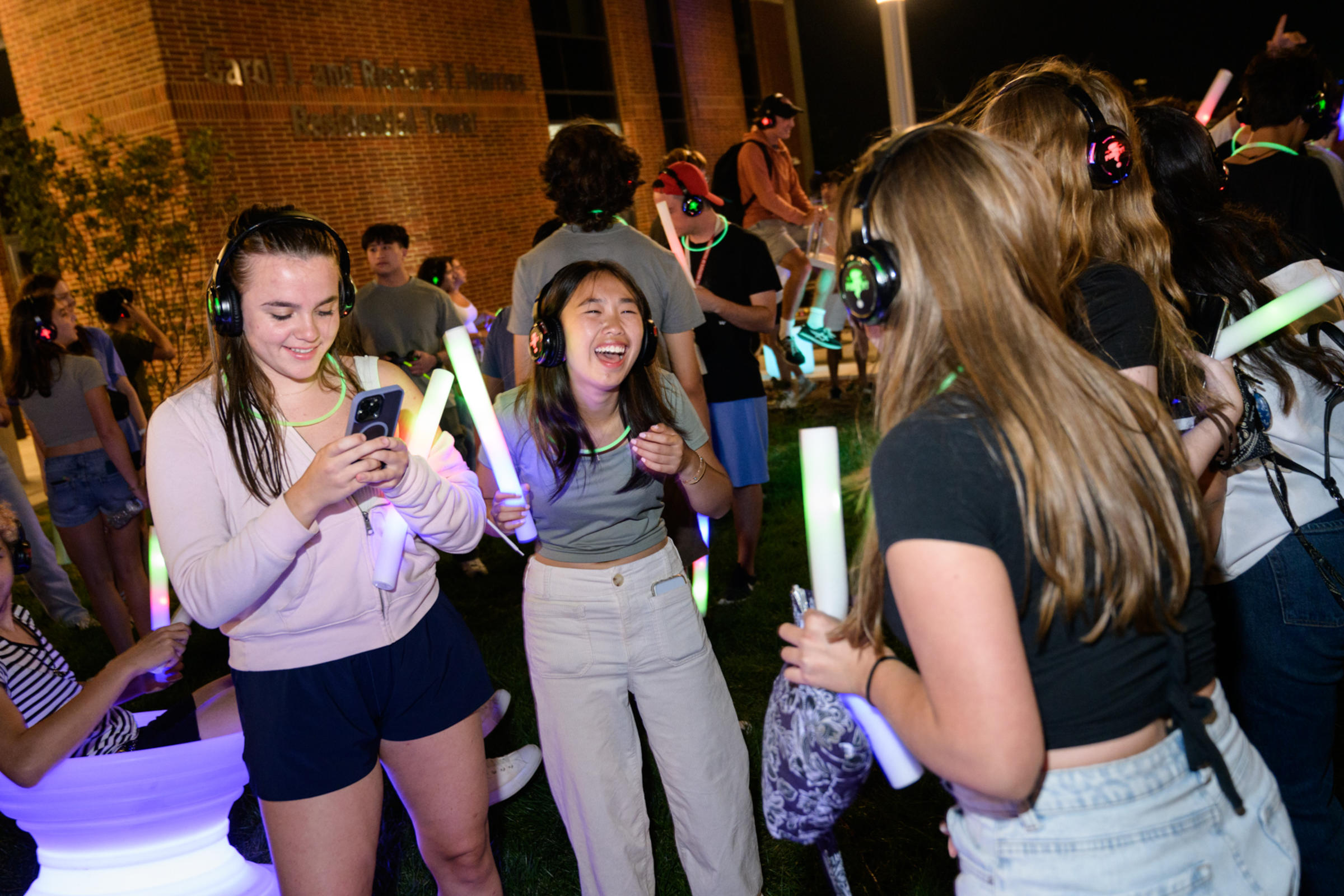 Students wear headphones and laugh during the silent disco near the UCC.