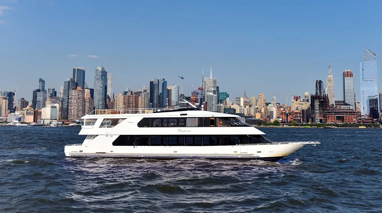 Cruise ship is in the Hudson River with skyline behind it 
