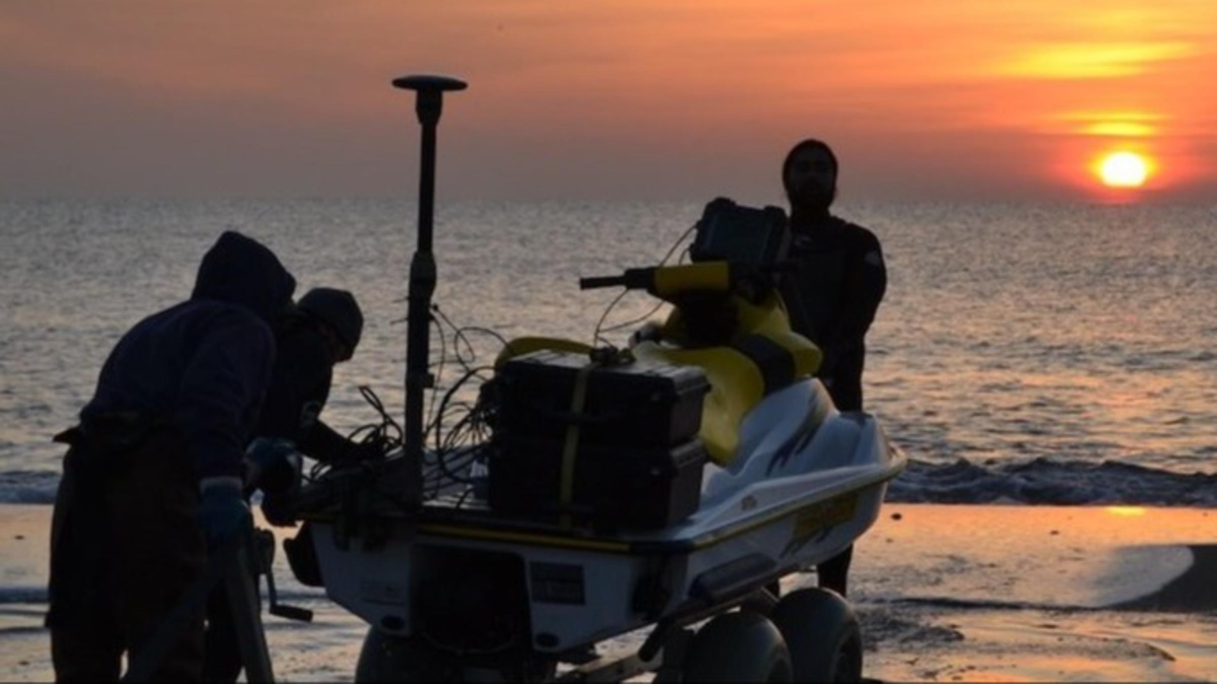 Jon Miller's coastal engineering research team at the beach with their jet ski.
