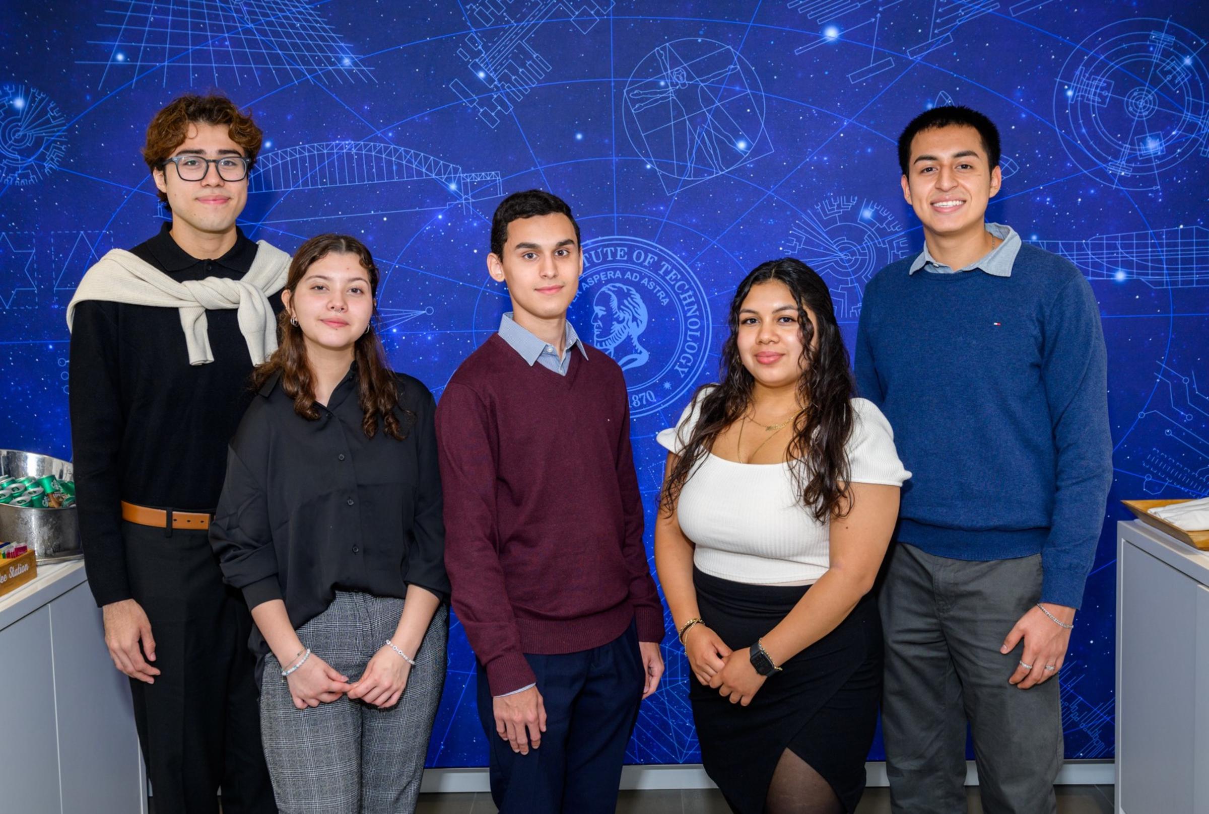 First-year students Jonathon Salmeron, Melissa Santiago, Andy Abreu, Allison Mendoza and Diego Veletanga pose in front of a blue wall.