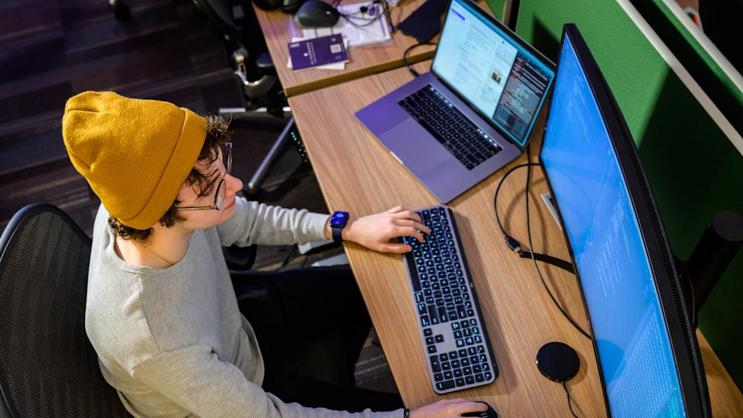 Top down view of a student working on a desktop computer.