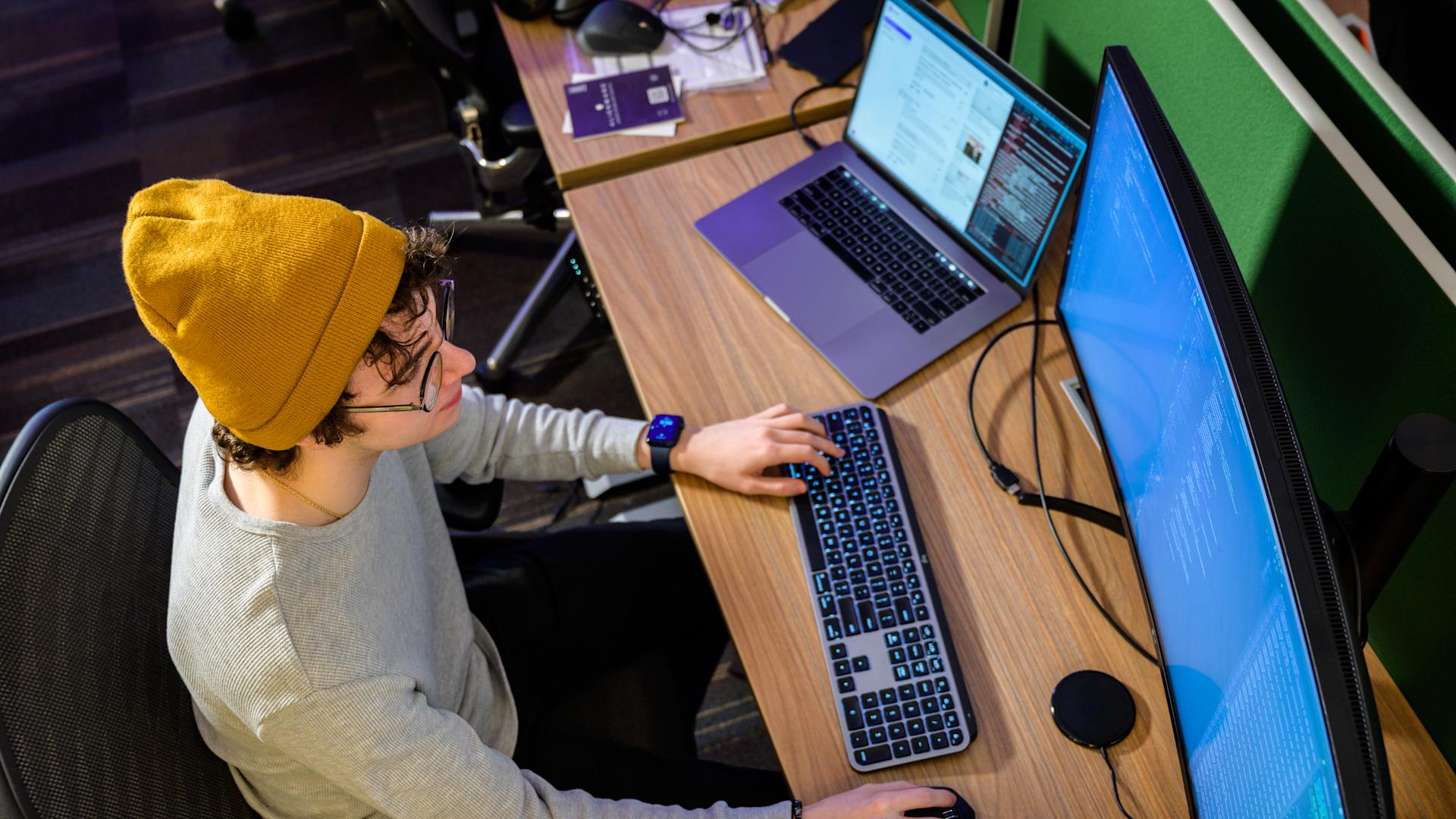 Top down view of a student working on a desktop computer.