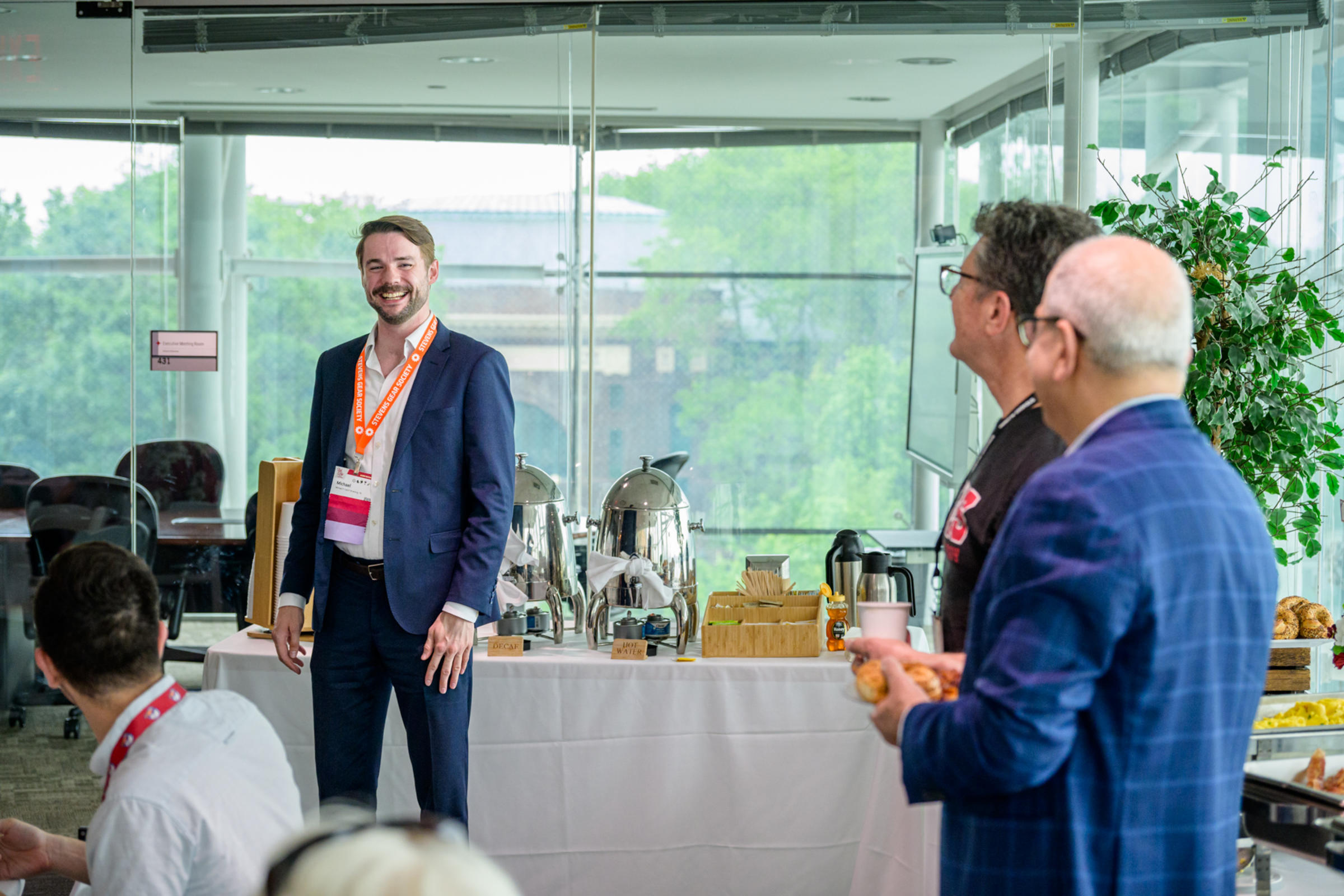 SAA President Michael F. Cahill ’15 M.Eng. ’15 smiles chatting with alumni at a breakfast event during Alumni Weekend 2025