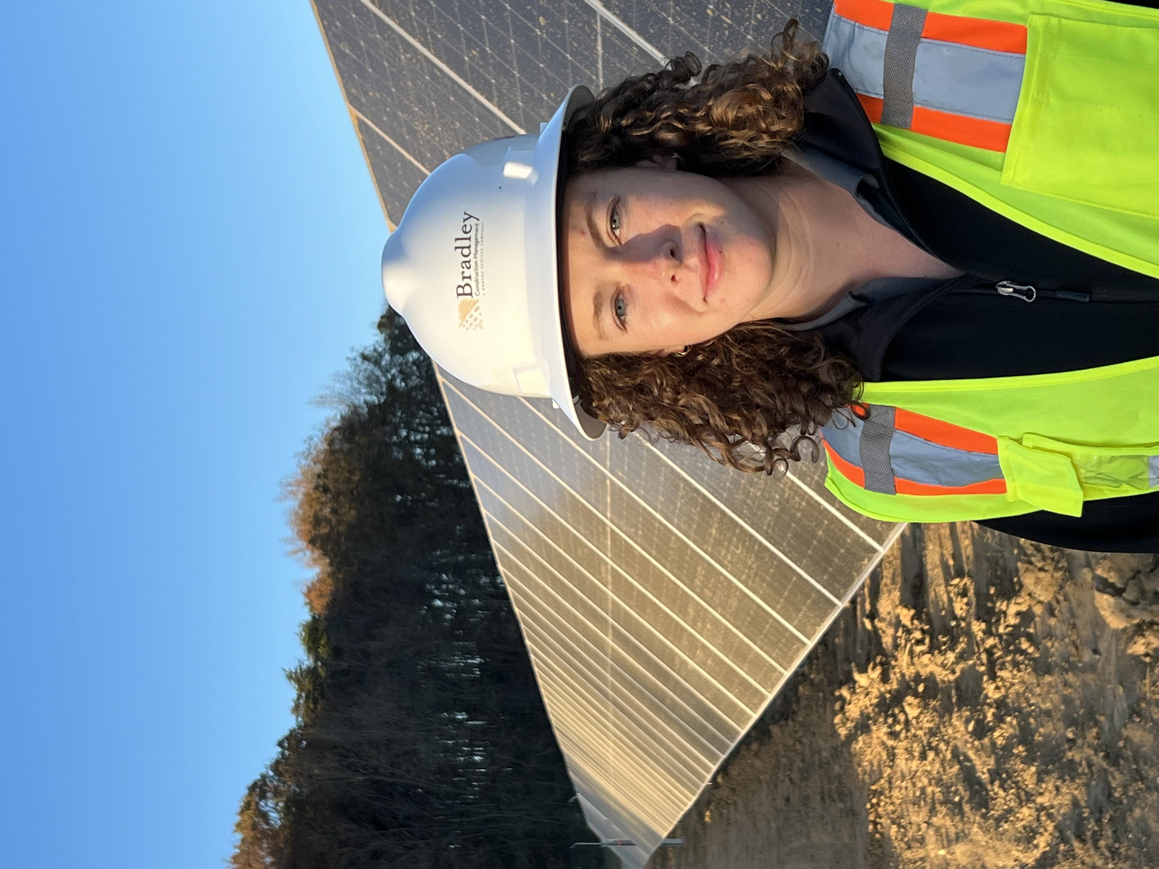 Jessica Driscoll stands in front of solar panels
