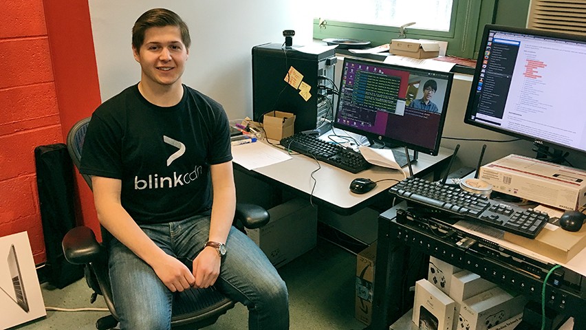Justin Trugman in the offices of Blink CDN at Stevens. A livestream video is in progress on one of the screens behind him.