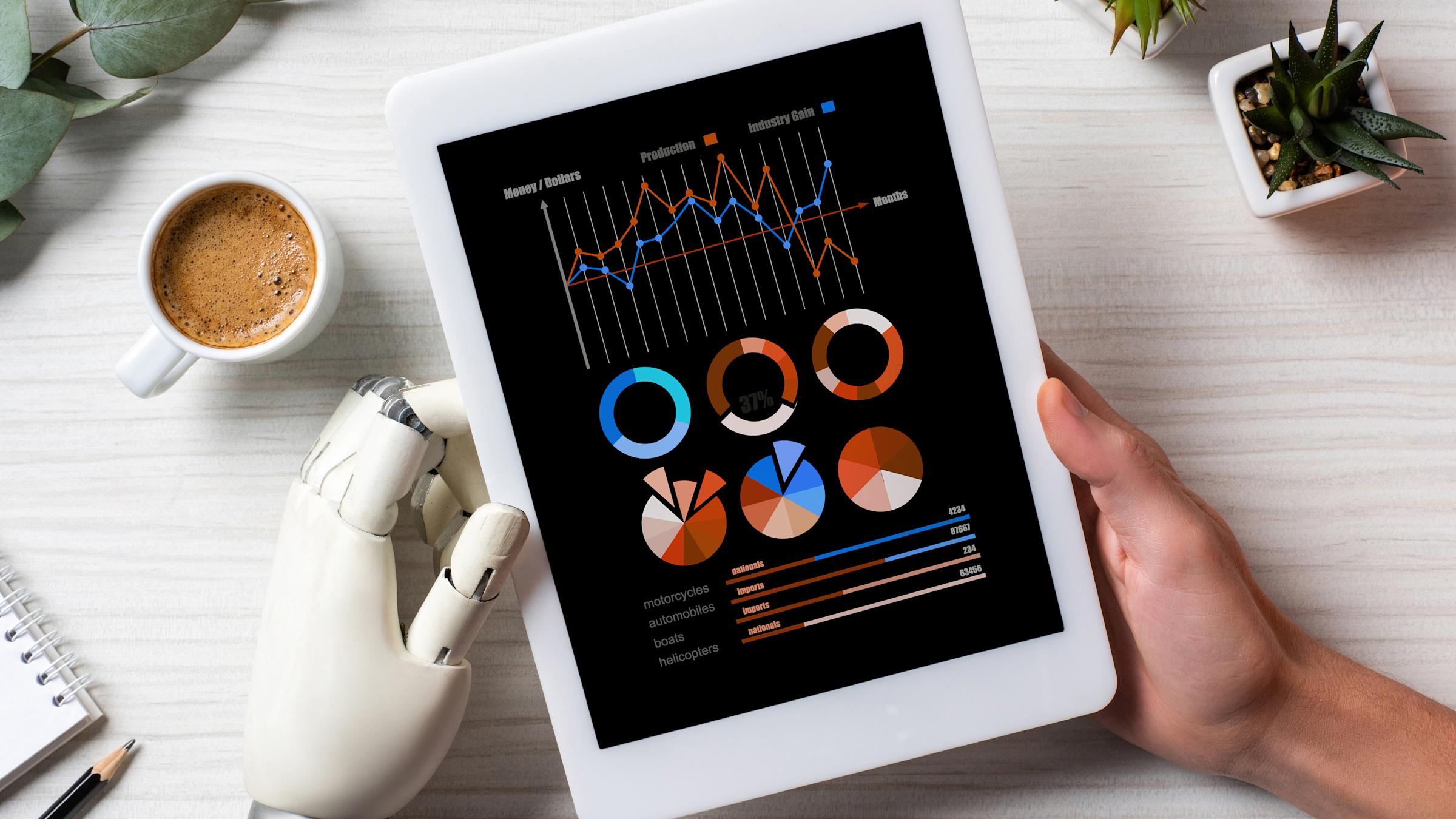 partial view of businessman with cyborg hand using digital tablet with infogrpahic on screen at