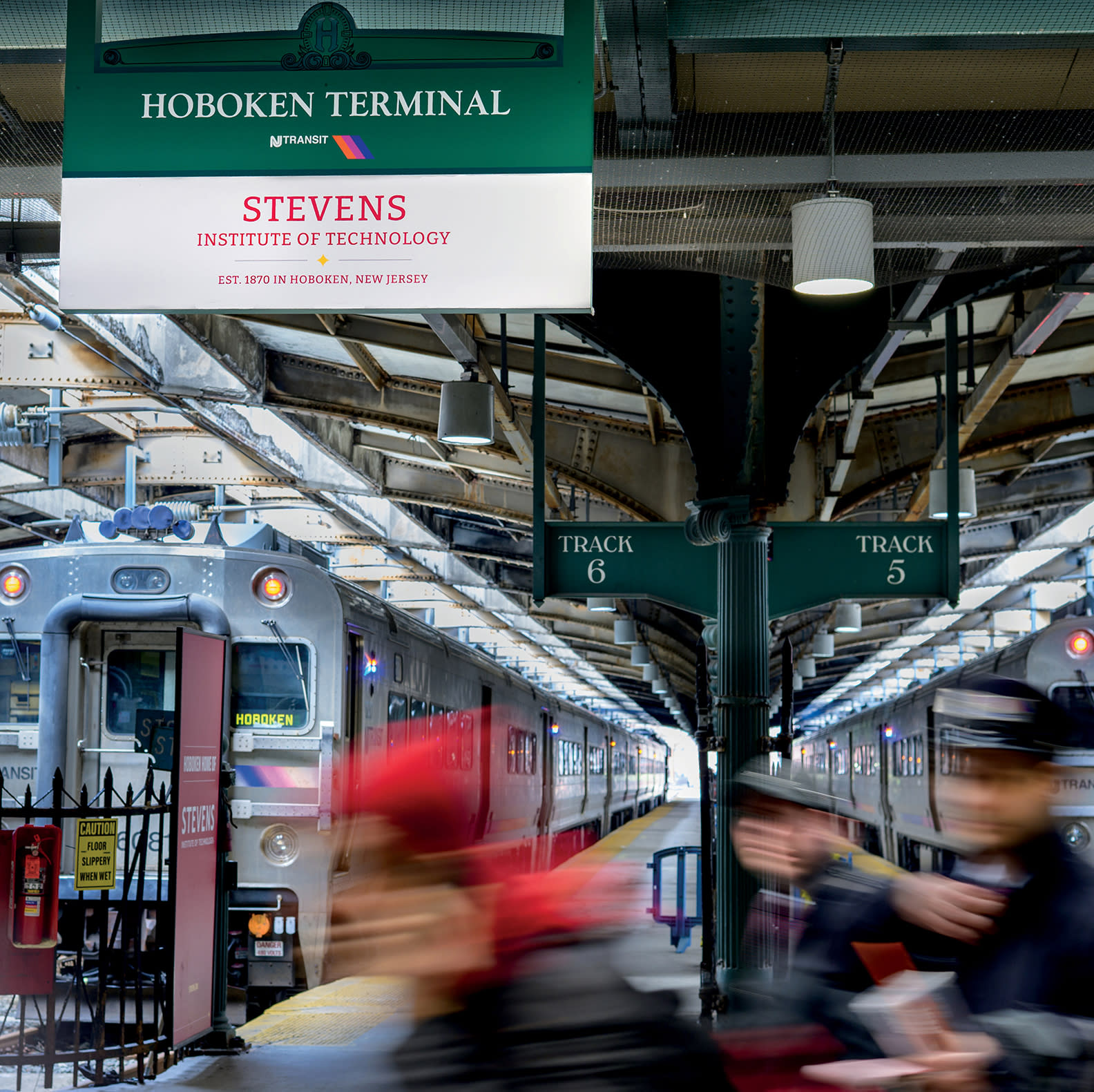 Interior of Hoboken train terminal with a sign that says "Stevens Institute of Technology".
