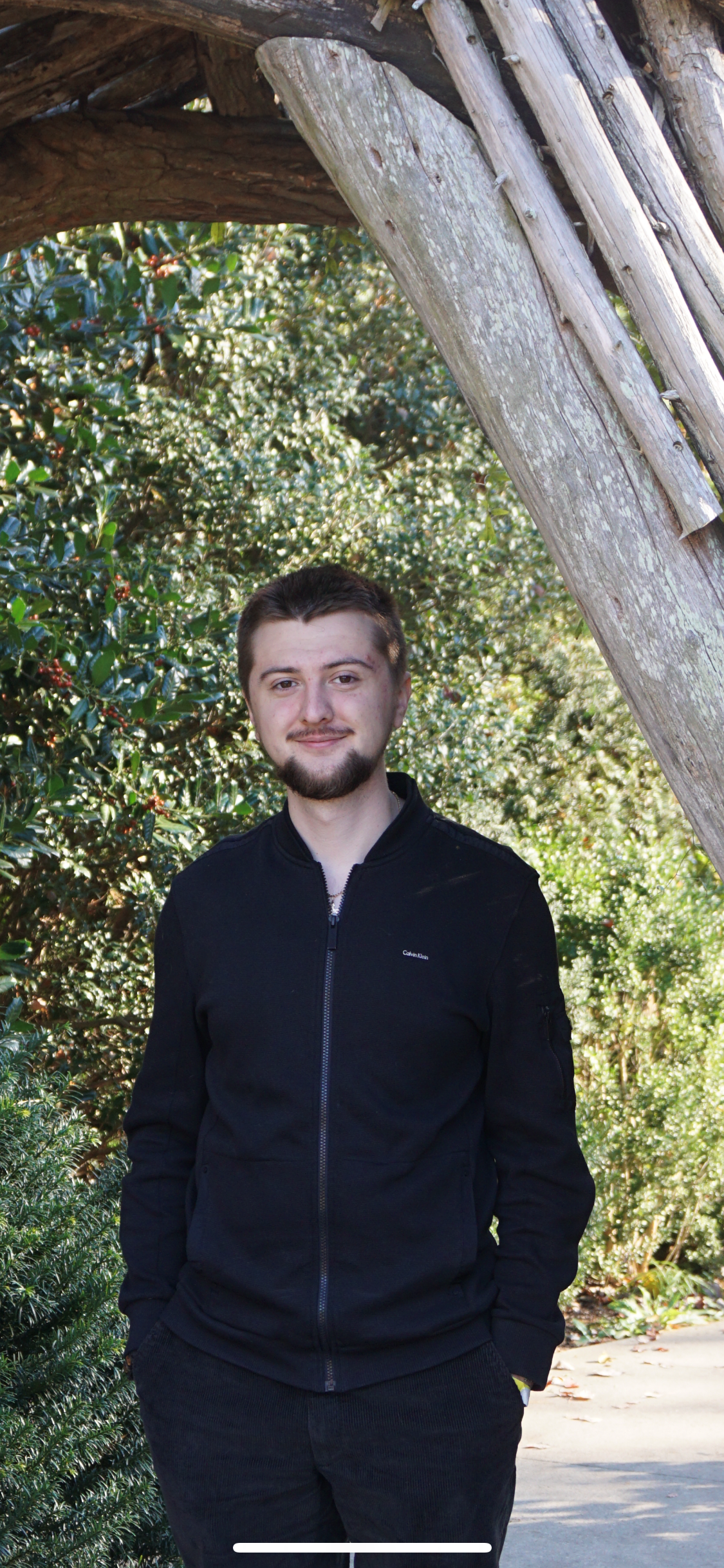 Aleksandr Grin outdoors standing near a tree