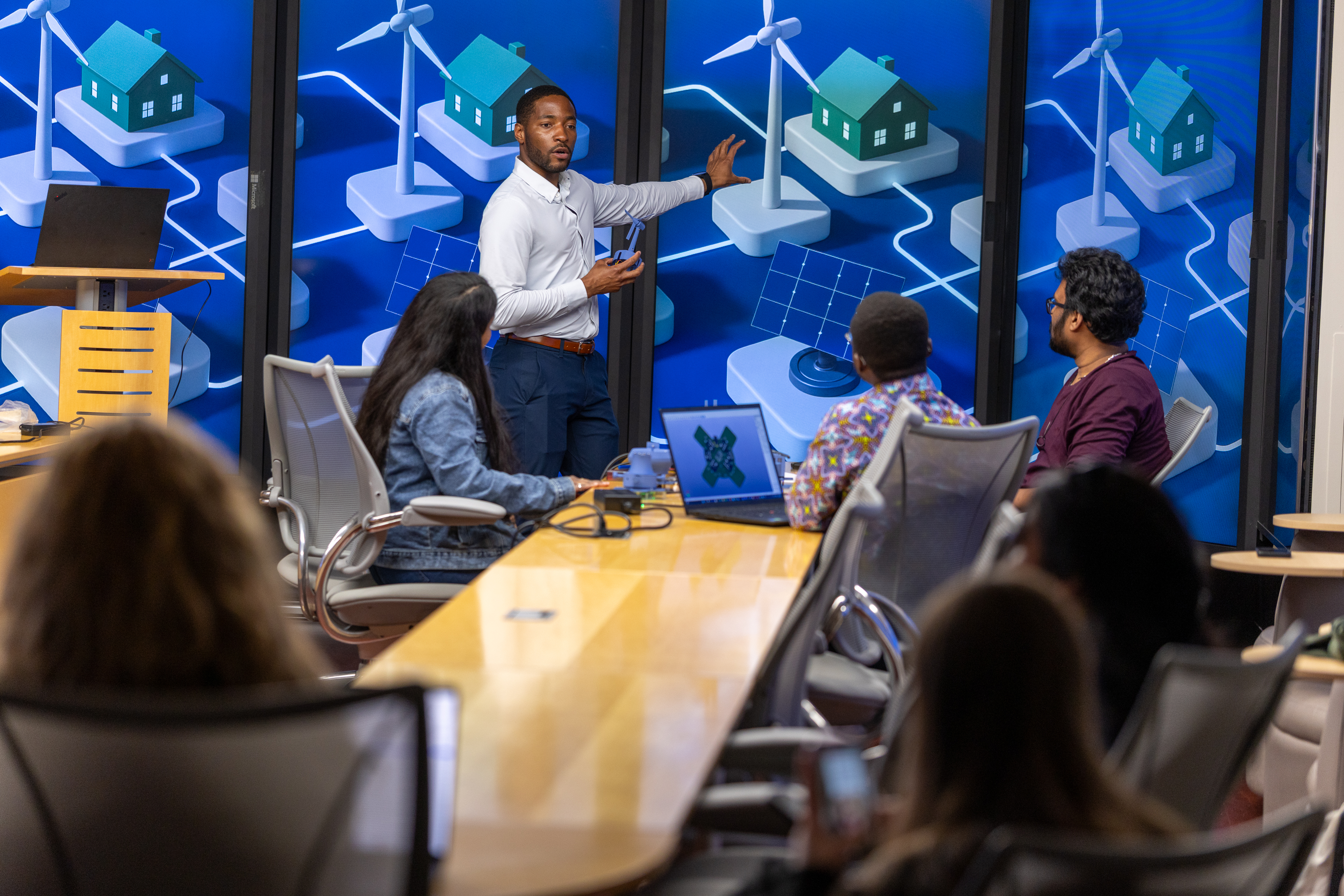 Stevens professor Philip Odonkor working with students in front of display monitors showing a city system.