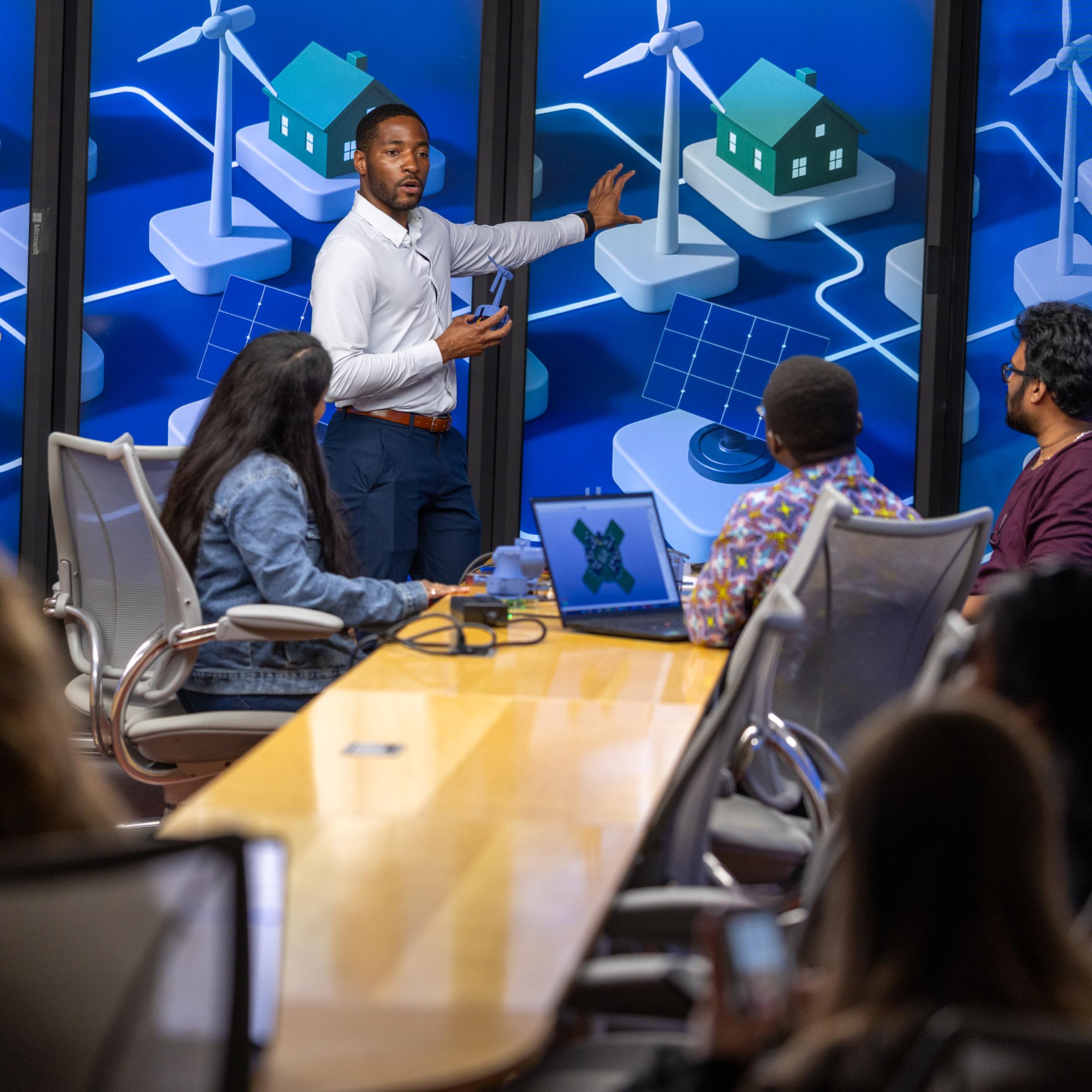 Stevens professor Philip Odonkor working with students in front of display monitors showing a city system.
