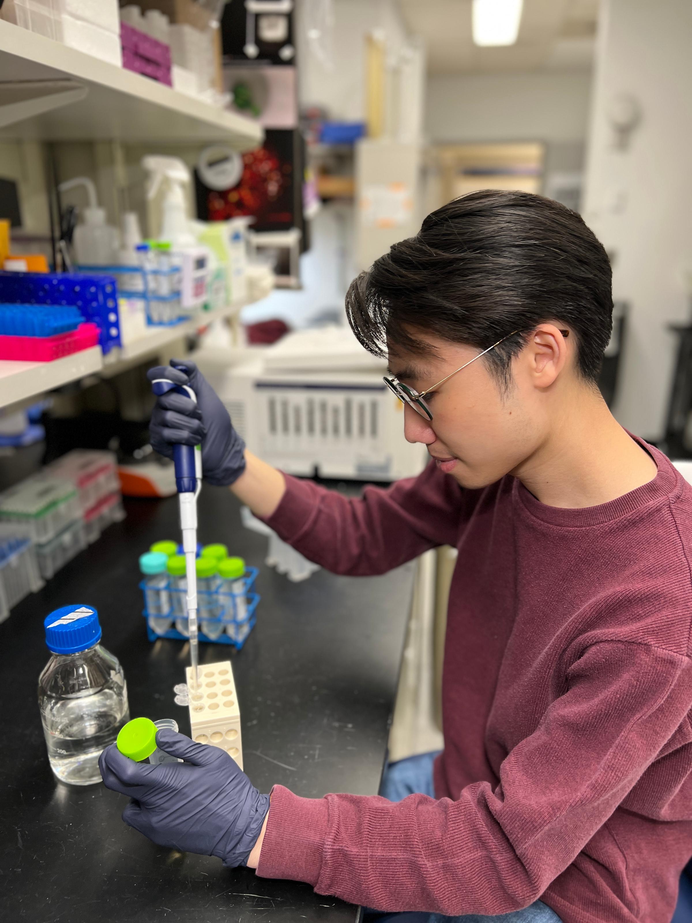 Photo of CCB student Douglas Kung doing an experiment with pipettes and test tubes in the lab