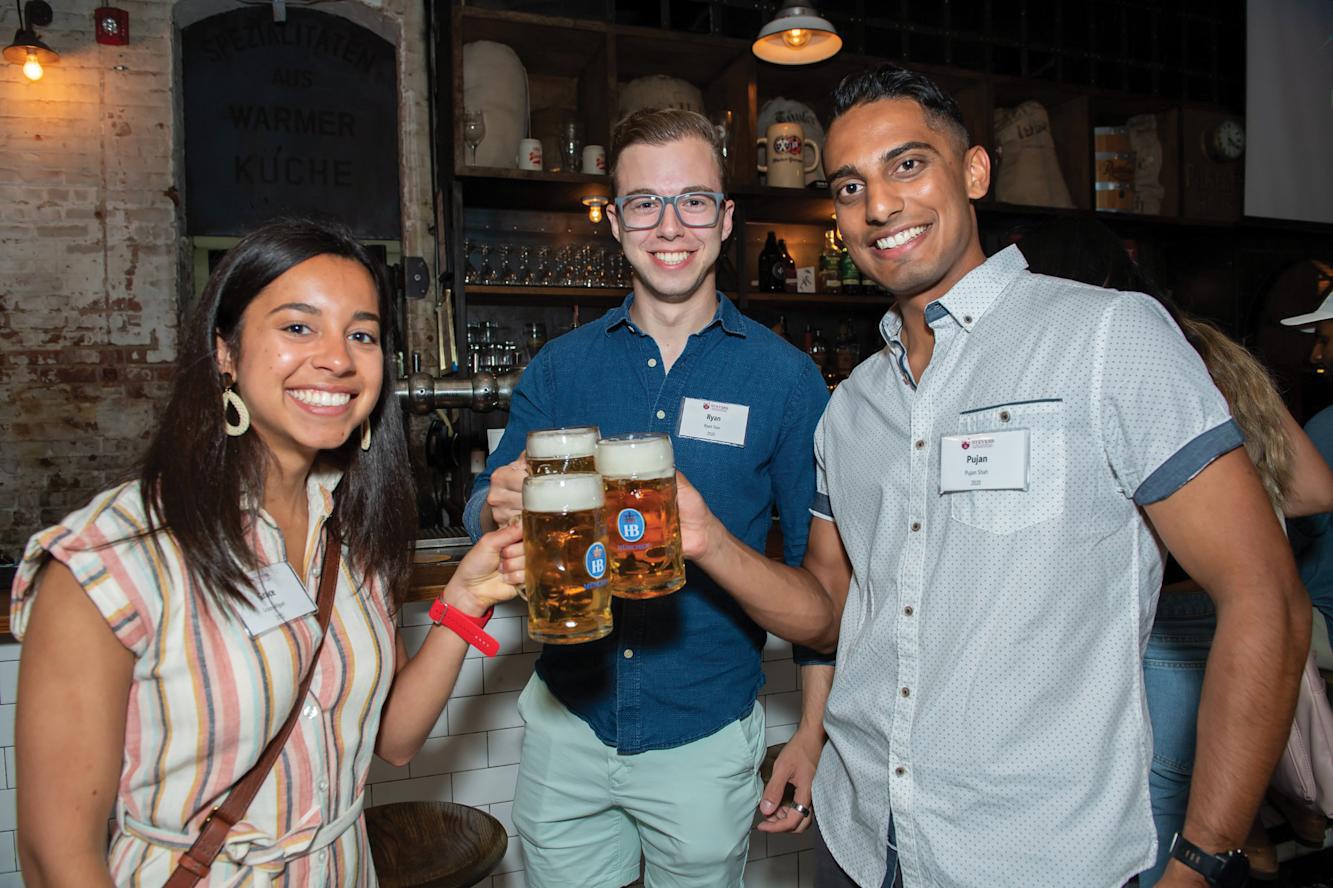 Three Stevens alumni toast beers.