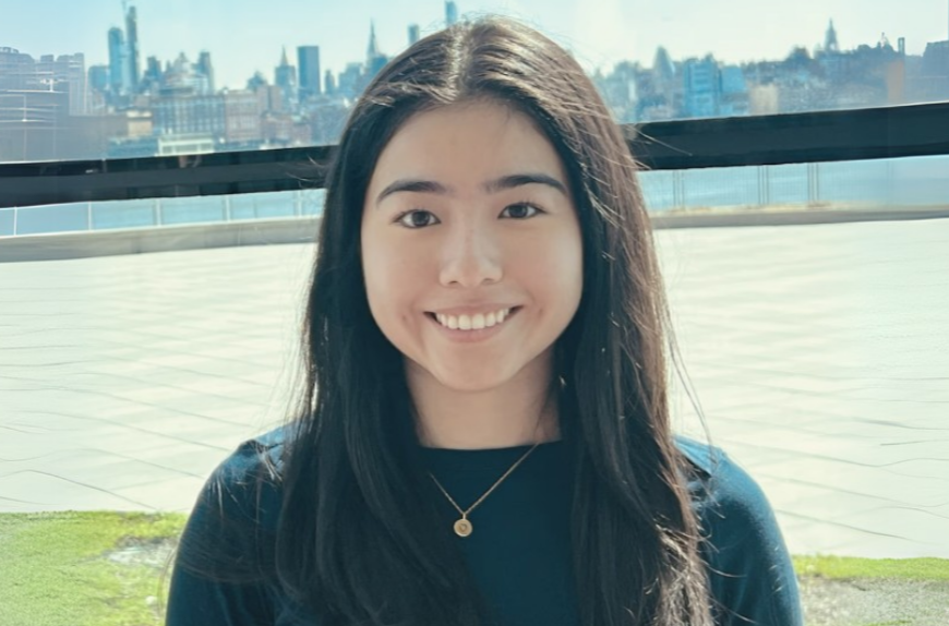 Stevens student Alexandra Garzon in the Babbio Center with Manhattan behind