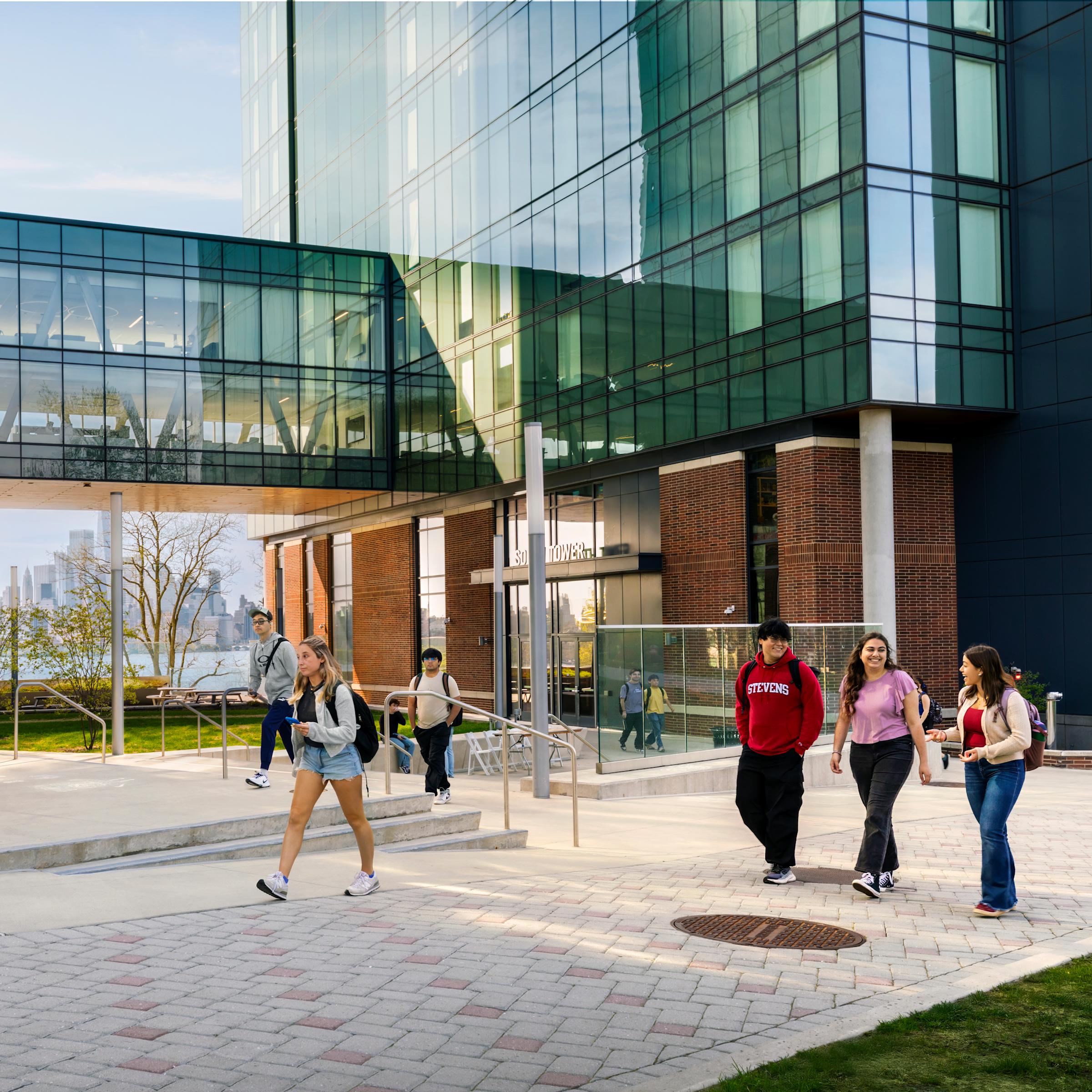 Students walking across UCC plaza with Manhattan skyline behind