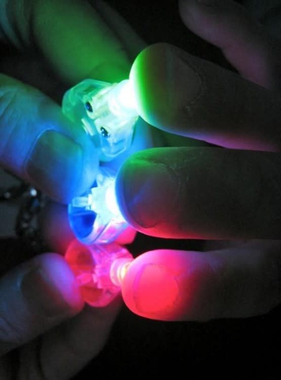 Fingers holding colored lasers.