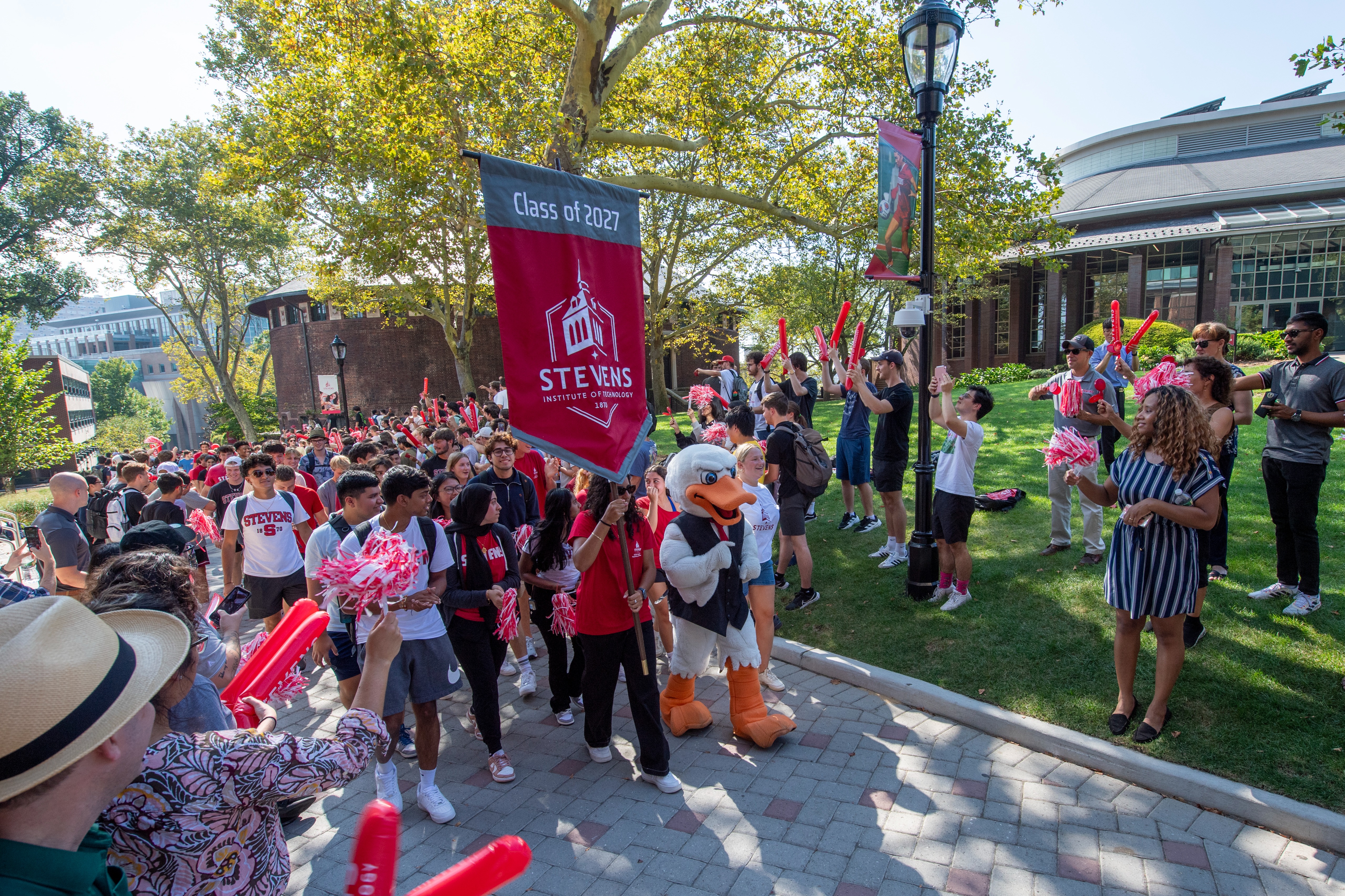 A group of students and Attila walking with a banner down Wittpenn Walk.