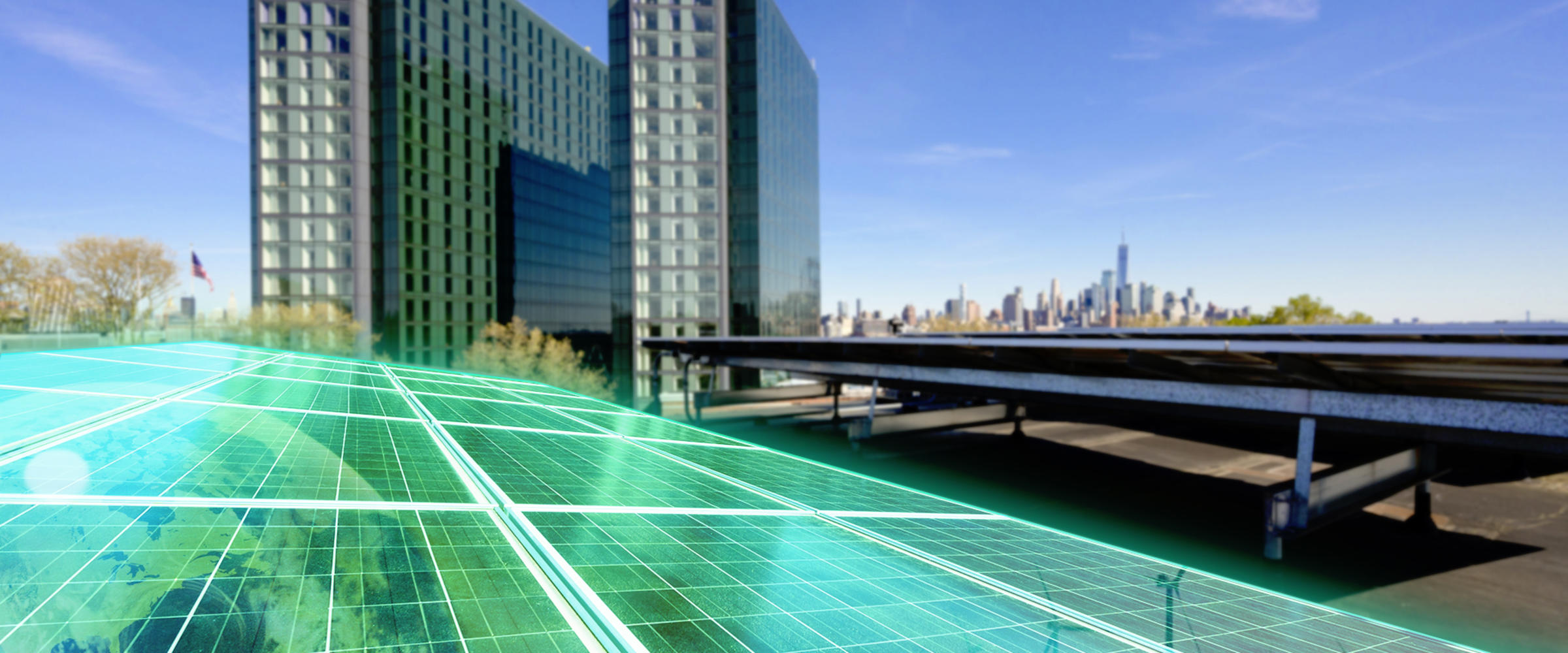 A solar panel highlighted in green sitting on a roof next to Stevens campus with a view of Manhattan.