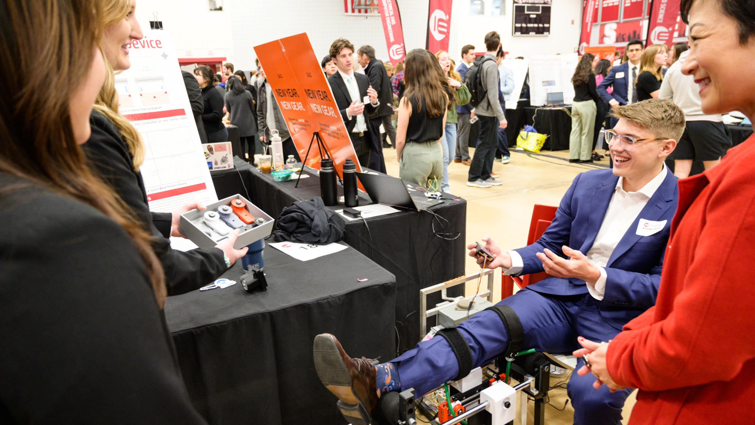 A student displays the Knee-sy Does it device as three people observe a demonstration.