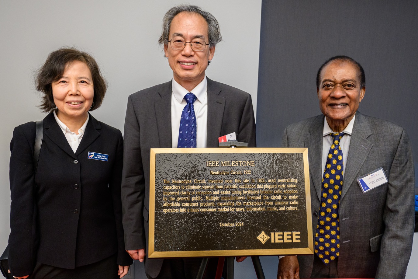 Hong Zhao, Min Song and Victor Lawrence pose in front of an IEEE Milestone plaque.