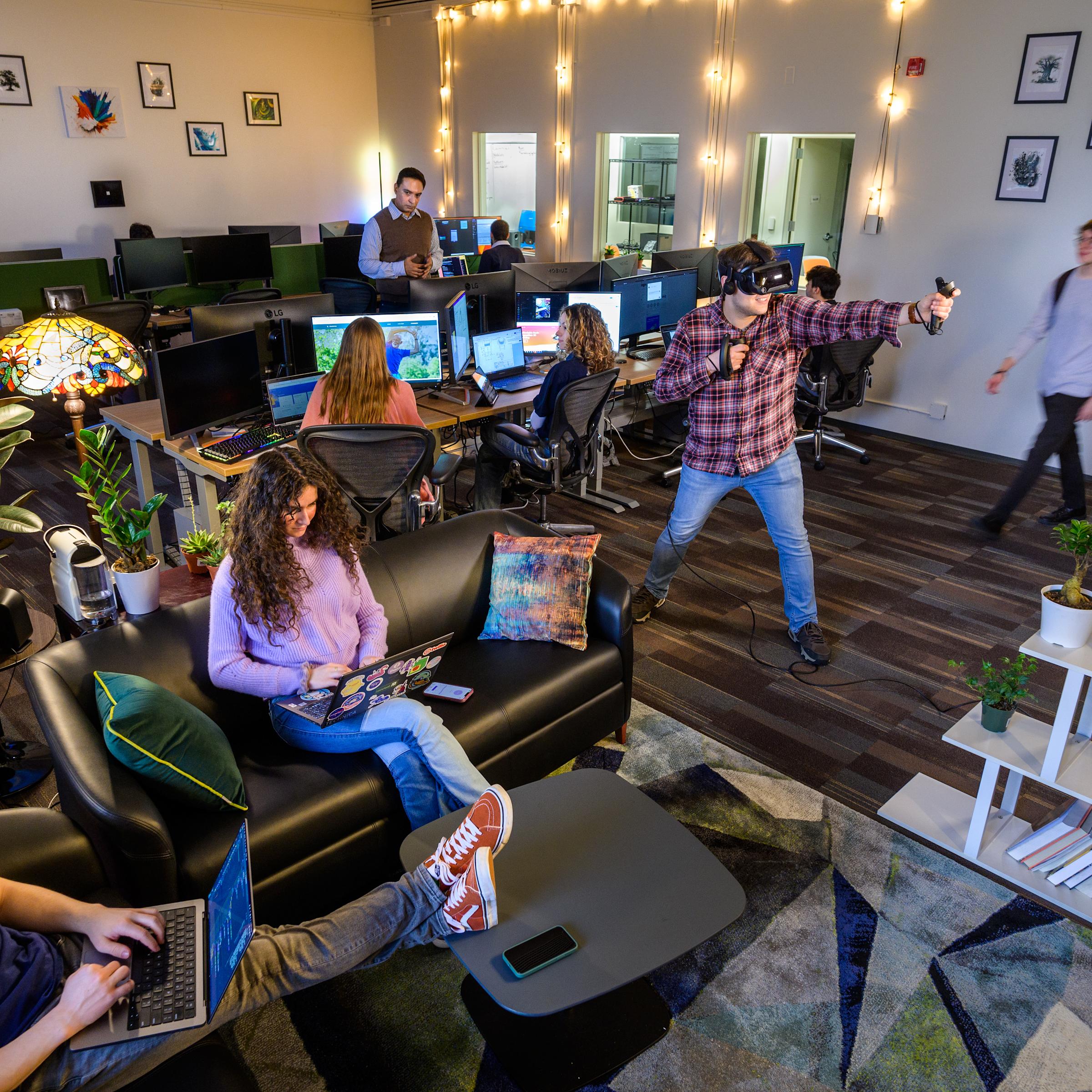 Students active in the Startup Garage, some on their laptops, another using a VR headset.